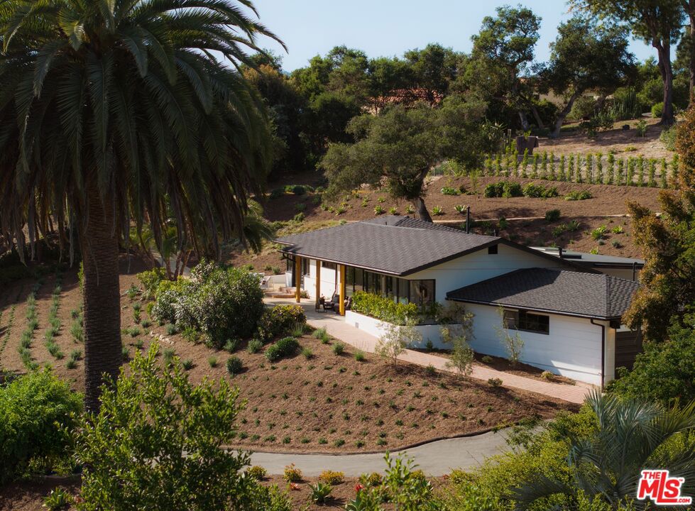 Don't miss this remarkable opportunity to secure a turnkey home in desirable Hope Ranch! Set on 1 full spacious acre in the heart of Hope Ranch yet only a few minutes from the beach, this fully updated and beautifully renovated 4 bedroom home offers a harmonious blend of sleek, modern design, and lush canyon panoramas. Practically every inch of the +/- 2,125 sq ft home has been thoughtfully remodeled and smartly configured. Major property upgrades include new septic, new flooring, new bathrooms, new roof, new heating and ventilation, new electrical, new plumbing, new landscaping, & more! From the first step inside, you'll be welcomed into the easy and comfortable flow of the home's open-concept floor plan. Expansive picture windows in the living room frame vibrant outdoor greenery and the canyon vistas beyond. A striking dual-sided fireplace connects the living and dining spaces, while metal-framed glass doors blur the boundaries between indoors and out. Wood paneling adds warmth and texture, creating an inviting contrast to the home's crisp lines and modern finishes. At the heart of the home, the breathtaking chef's kitchen is both stylish and functional, boasting abundant counter space, a stunning wall-to-wall backsplash, and a spacious breakfast nook and bar. Multiple skylights illuminate the kitchen and central dining areas, adding to the home's bright and airy ambiance. At the far end of the home, the primary suite provides a serene getaway, complete with a generous walk-in closet, a bathroom suite with luxurious quartzite flooring, a spa shower, a large soaking tub, and double vanity. The primary suite also features French doors leading to an outdoor sitting area and a manicured walking trail on the property. Three additional bedrooms offer space and flexibility, including a bedroom located at the other end of the home, ensuring ample privacy when needed. Outside, multiple patios and lookout points are surrounded by a variety of trees, including a newly planted fruit orchard and tasteful landscaping featuring native California coastal foliage, creating the perfect setting for relaxing, dining, or simply taking in the peaceful views. Additional property features include a 2-car garage, generous driveway parking, and plenty of usable space to add a resort-style pool or an ADU, offering flexibility for future possibilities. Combining comfort, simplicity, and modern design, this move-in-ready home invites you to live in sophisticated ease immersed in nature while enjoying the elegant way of life that defines the Hope Ranch community. Hope Ranch residents can enjoy private beach access, bridle & equestrian trails, dedicated security patrol, community tennis courts, and convenient proximity to the La Cumbre Country Club & Golf Course.