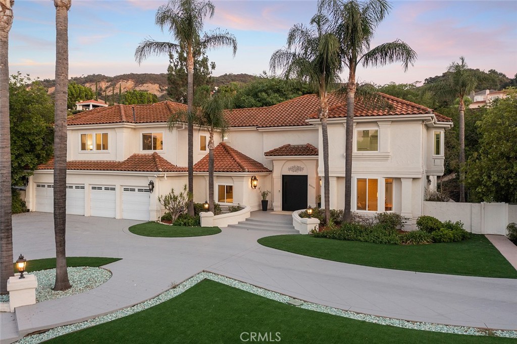 Elegant Mediterranean Estate in Guard-Gated Mountain Park Estates, Welcome to this extraordinary Mediterranean-inspired estate, gracefully situated on a private, flat 1.3-acre corner lot within the exclusive, guard-gated enclave of Mountain Park Estates. Tucked at the end of a quiet cul-de-sac, this meticulously remodeled residence offers 7 bedrooms, 6.5 baths, and approximately 5,357 square feet of refined living space, expertly designed for comfort, privacy, and elevated living. The home welcomes you with impeccable curb appeal, featuring a grand circular driveway, dual 2-car garages, and a private tennis/basketball court. Inside, soaring ceilings and expansive windows bathe the interiors in natural light, complementing the warm, timeless design and extensive custom millwork throughout. Two luxurious primary suites—one on the main level and another upstairs—offer ultimate flexibility and privacy. Both feature oversized, custom walk-in closets and spa-inspired smart bathrooms with premium finishes and modern conveniences.
Designed for both entertaining and everyday living, the home includes a formal living room with fireplace, a spacious family room, formal dining room, and a versatile bonus room ideal for a playroom, study, or media lounge. The gourmet chef’s kitchen is a true centerpiece, boasting abundant custom cabinetry, an oversized center island, and generous prep and gathering space for hosting holidays and memorable evenings. Step outside to enjoy the resort-style grounds, complete with a sparkling pool and spa, full-size sport court with basketball hoops, outdoor kitchen/BBQ center, multiple patios and seating areas, and wide open lawns perfect for entertaining or relaxing in privacy. A detached guest house with its own bedroom and full bath offers ideal accommodations for visitors or extended family. Residents of Mountain Park Estates enjoy access to a private community park with lighted tennis courts, soccer and baseball fields, playgrounds, and direct trail access to the Santa Monica Mountains, offering hiking and biking with breathtaking ocean views.
Located just minutes from award-winning Las Virgenes schools, upscale shopping, fine dining, and the best of Calabasas and Malibu, this rare estate represents the perfect blend of luxury, function, and serenity. DO NOT MISS OUT .