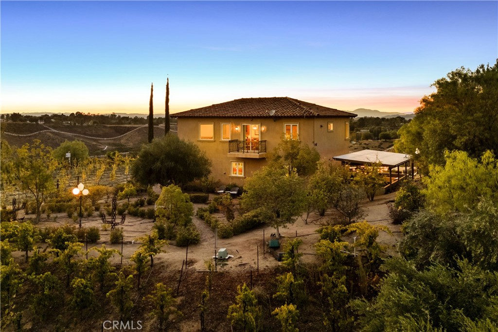 A rare and distinguished offering in the heart of Temecula's prestigious De Portola Wine Trail. This extraordinary 10.38-acre parcel is not merely a residence; it is a fully realized opportunity for a private luxury estate or an emerging artisanal winery.
The Vineyard Foundation: The acreage currently hosts meticulously maintained varieties of Cabernet Sauvignon, Cabernet Franc, and Zinfandel, providing an immediate, high-quality foundation for a boutique label. With desirable Winery District zoning, the property is poised for the development of a Class II winery, providing an ambitious owner with the permits to craft, bottle, and market their own Temecula Valley vintage.
The Residential Retreat: The charming two-story residence serves as an elegant owner's retreat or a sophisticated tasting room prototype. Featuring dual-facing balconies, the home is perfectly sited to capture panoramic 360-degree views—from the morning spectacle of hot air balloons to the majestic Palomar Mountain at sunset. The dedicated winemaking room and four-car garage offer the practical infrastructure for both private and commercial operations.
The Visionary Potential: Beyond the existing structures, a generously sized pad presents a unique architectural canvas for expansion—be it an elevated custom villa, a world-class hospitality venue, or a serene pool oasis. Situated directly across from acclaimed Leoness Cellars, this is an unparalleled chance to secure a legacy-grade holding in one of Southern California's most dynamic viticultural regions. This is the definition of wine country provenance.