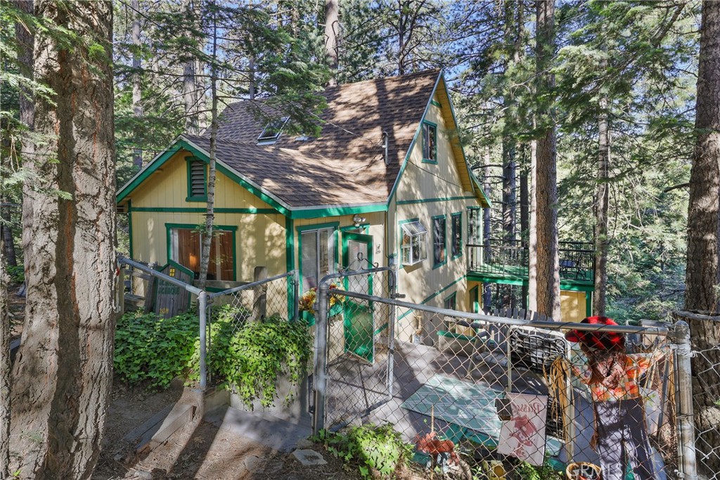 Escape to the mountains in this inviting 2-bedroom, 1-bath cabin nestled in the serene community of Twin Peaks. With 948 square feet of cozy living space, this home offers the perfect blend of rustic charm and modern comfort and is just the right size for weekend trips or a peaceful full-time home. Wood-beam ceilings and large windows bring warmth and natural light to the living and dining areas. Additional features include a generous, secure storage area and a workshop on the first level, accessible via a separate entrance. Step outside to enjoy the fresh mountain air from the open deck—ideal for morning coffee or evening stargazing. The adjacent lot is included and features a spacious, convenient 2-car parking deck, offering rare and valuable off-street parking, as well as potential for future expansion or outdoor entertainment space. Explore the nearby trails, go fishing at picturesque Gregory Lake, and enjoy the beauty of the lake, as well as the charming shops and restaurants in town. When the snow falls, you can go sledding in your backyard, creating lasting memories with your family and friends. This turn-key property is ready for its next family to experience the unique charm of traditional cabin living. Whether you're looking for a weekend retreat, full-time residence, or vacation rental, this cabin offers an incredible opportunity to own a slice of peaceful mountain living with added flexibility and value. Owned by the same family for over 50 years! Don't miss your chance to make this charming getaway your own! Schedule a showing today!