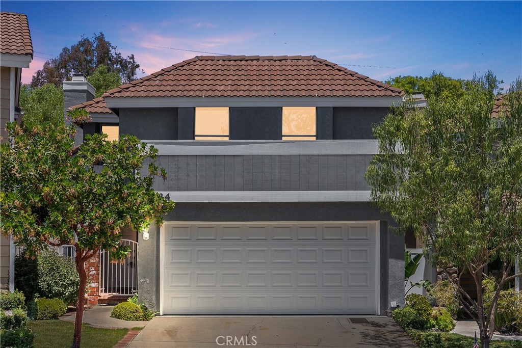 Set in the coveted California Cove enclave of Laguna Beach, this charming two-story residence blends thoughtful updates with the rare opportunity to access top-rated Laguna Beach schools at an exceptional value. Nestled in the quiet hillsides of Laguna Canyon, the home offers a tranquil setting just minutes from the vibrant beaches, shops, and restaurants of downtown. A vaulted entry opens into a bright, inviting living and dining space where soaring ceilings, tall windows, and a dramatic ceiling-height brick fireplace create an airy sense of volume and warmth. Natural light flows easily throughout, while the open-concept layout connects seamlessly to a private rear patio—an ideal space to relax, entertain, or enjoy the surrounding greenery. The kitchen has been tastefully upgraded with quartz countertops, white shaker cabinets, stainless steel appliances, and a convenient breakfast nook. A built-in bar area adds character and function to the main level, perfect for gathering with friends or hosting casual evenings at home. Upstairs, the primary suite features a walk-in closet and en-suite bath with dual vanities. Two additional bedrooms share a full bath, while a spacious bonus room offers flexibility as a fourth bedroom, home office, or creative studio. With a low monthly HOA, an attached two-car garage, and easy access to hiking trails, parks, and the award-winning Laguna Beach Unified School District, this home presents a unique opportunity to enjoy the best of coastal Orange County—without the coastal price tag.