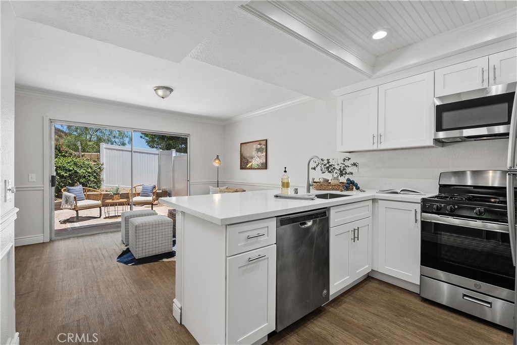 Located in the coveted California Cove enclave of Laguna Beach, this charming two-story residence blends thoughtful updates with the rare opportunity to access top-rated Laguna Beach schools at an exceptional value. Nestled in the quiet hillsides of Laguna Canyon, the home offers a tranquil setting just minutes from the vibrant beaches, shops, and restaurants of downtown. A vaulted entry opens into a bright, inviting living and dining space where soaring ceilings, tall windows, and a dramatic ceiling-height brick fireplace create an airy sense of volume and warmth. Natural light flows easily throughout, while the open-concept layout connects seamlessly to a private rear patio—an ideal space to relax, entertain, or enjoy the surrounding greenery. The kitchen has been tastefully upgraded with quartz countertops, white shaker cabinets, stainless steel appliances, and a convenient breakfast nook. A built-in bar area adds character and function to the main level, perfect for gathering with friends or hosting casual evenings at home. Upstairs, the primary suite features a walk-in closet and en-suite bath with dual vanities. Two additional bedrooms share a full bath, while a spacious bonus room offers flexibility as a fourth bedroom, home office, or creative studio. With a low monthly HOA, an attached two-car garage, and easy access to hiking trails, parks, and the award-winning Laguna Beach Unified School District, this home presents a unique opportunity to enjoy the best of coastal Orange County—without the coastal price tag.
