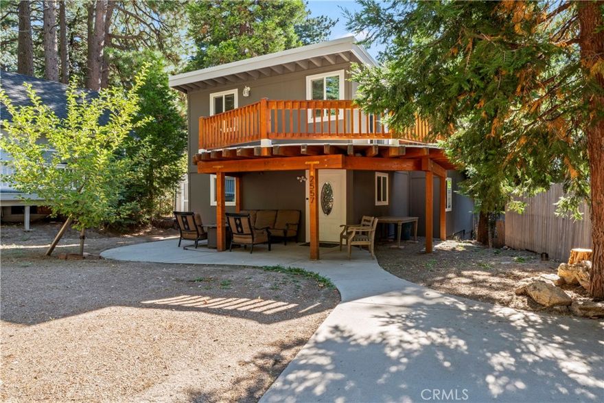 Discover your perfect mountain getaway in this level-entry home set on a spacious double lot (2557 Whispering Pines lot adds 3,314 sf for a total of 8,683 sf), tucked away from the street for extra privacy. Whether you're dreaming of full-time living or want an ideal spot for short-term rentals, this beautifully updated home offers versatile comfort and modern style. Step inside to an inviting main floor where a sleek kitchen with stainless steel appliances and granite countertops flows seamlessly into the dining and living areas. Enjoy cozy evenings by the built-in electric fireplace with decorative lighting, while custom details add warm character throughout. Find one bedroom, a full bath with stackable laundry hookups, and a flexible bonus room for work, guests, or play. Upstairs, unwind in the oversized private bedroom featuring beamed ceilings, a walk-in closet, extra linen storage, and sliding glass doors that open to a large balcony - perfect for taking in serene nature views. Fresh, neutral décor lets you add your own style, while new central heating with a smart thermostat, double pane windows, a commercial-grade roof, tankless water heater, and new exterior paint grant peace of mind and year-round comfort. Outside, the possibilities abound with plenty of parking, a covered deck entrance, an outdoor storage shed with water, and a level yard ready for a fire pit and easy entertaining under the stars. There’s even an extra lot included with the property for future expansion. Enjoy the best of mountain living just minutes from town amenities - farmer’s market, dining, library - and easy access to Hwy 330, Snow Valley ski slopes, Lake Arrowhead, and Big Bear. Embrace a lifestyle of relaxation and adventure in this inviting home that truly has it all.