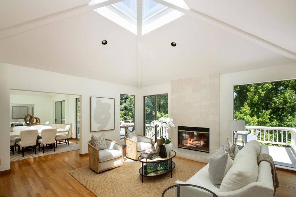 Offering the convenience of townhome living, and with just one shared wall, this home is a rare find in a coveted community of just 18 homes. Adjacent to one of two community gates, and overlooking lush foliage and green belts, the location is superb. Freshly painted interiors and beautiful hardwood floors span the two levels, which includes six signature pyramid-style vaulted ceilings, three with large skylights at the apex. Adding to the natural light are sliding glass doors in almost every room opening to inviting private decks and patios on both levels. There are 3 bedrooms and 3 full baths, including a main-level bedroom with a Murphy bed and custom office built-ins - perfect for today's work-from-home needs. Completing the appeal is a finished bonus room, an attached 2-car garage, community pool, and a park-like setting of 8 acres that is just blocks to the Los Altos Village.