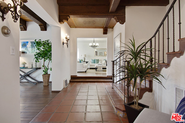 This Spanish Revival gem, with its original charm and character intact, portrays the quintessential history of the coveted Beverly Hills flats. A dramatic entrance leads you through this gracious residence, featuring a spacious, formal living room with a high-stenciled wood beam ceiling. The open floorplan leads you through the family room to formal dining room with doors leading to the rear patio, perfect for outdoor entertaining and dining al fresco. Additional features include a bonus office space and maids bedroom and bathroom off the kitchen. The second level consists of 3 bedrooms, all with en-suite bathrooms. A gated driveway, detached 2 car garage, and a 1 bedroom 1 bath guest house with alley access complete the rear of the residence surrounded by lush fruit trees with plenty of room for a pool. Ideally located on one of the best streets in the flats, just minutes from top ranked schools and the best shopping and dining Beverly Hills has to offer.