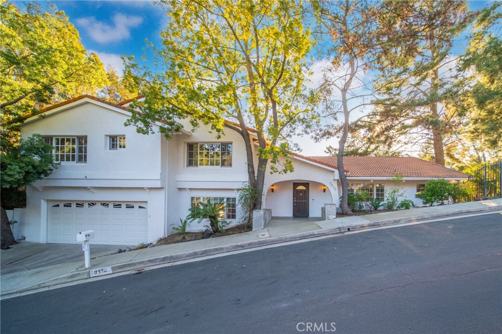 A beautifully designed residence filled with natural light, soaring vaulted ceilings, and an inviting open floor plan. The first level features elegant wood floors and seamlessly connects the grand living and family rooms, both warmed by a cozy fireplace, to a tranquil outdoor patio. The gourmet kitchen, with granite countertops and a charming breakfast nook, flows effortlessly into a secluded garden retreat. Upstairs, generously sized bedrooms complement the expansive primary suite, which offers a private balcony with serene treetop, canyon, and pool views. Lush gardens provide a peaceful setting for relaxation. Nestled on a quiet, private street just minutes from the vibrant shops and restaurants of Beverly Hills, this home is a wonderful blend of charm, comfort, and timeless appeal.