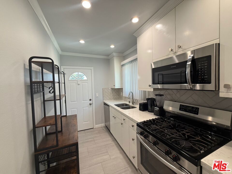 Welcome to your new home in a gorgeous remodeled 1-bedroom, 1-bathroom upper unit within a charming retro 50's triplex. This unit has been thoughtfully updated in 2023 and features luxurious vinyl flooring and a modern designer color palette throughout. The spacious living area is highlighted by crown moulding, gleaming hardwood floors and recessed lighting, creating a warm and inviting atmosphere. The kitchen is equipped with a updated stove, dishwasher, microwave, Samsung refrigerator, making meal preparation a delight. Triple-glazed windows and fresh vertical blinds ensure a serene living experience. The bedroom is designed for comfort with a ceiling fan and stunning floor-to-ceiling sliding mirror closet doors, providing ample storage. Enjoy year-round comfort with central heating and air conditioning. Convenience is key with on-site laundry facilities and an included outdoor parking spot. A small unlocked storage area in the garage provides additional space for your belongings. For pet lovers, the property welcomes pets with a separate pet lease and security deposits.This stylish and secure apartment is ready for you to move in and enjoy modern living in a classic setting. Don't miss your chance to call this exceptional space your own!