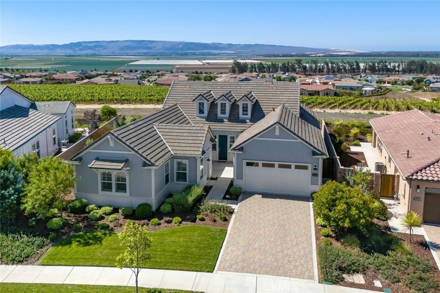 Here’s your opportunity to own a beautiful coastal exterior Ventana home, located on a super premium lot with a panoramic view of vineyards and hills to the south, plus the ocean and dunes to the west - it’s simply breathtaking! This gorgeous solar home offers 2,517 sq. ft. of prime living space with 3 bedrooms, 3.5 baths, (which includes a guest wing with private entrance), plus a den. Step inside and discover a stunning open-concept kitchen/great room/dining area with natural plank engineered wood floors and incredible views, which surround the outdoor space, lending itself to seamless indoor/outdoor living. You’ll love the centrally-located culinary kitchen with soft ivory colored quartz countertops and island combined with rich, upgraded espresso Shaker-style cabinetry - it’s an inviting combo that continues throughout. Top it off with the latest flush-mounted GE Profile stainless appliances, including a 5-burner gas cooktop, white tile backsplash, brushed nickel fixtures, and a spacious walk-in pantry - large parties or small gatherings, this space can handle it with ease. Outside, the landscaping is impeccable with covered patio, meandering pathways, low-maintenance plants and shrubs, artificial turf and ambient lighting - all with incredible views in every direction. The versatility of this home continues when you host family and friends for overnight stays, you’ll have plenty of room with a large bedroom and full bath next door, plus a guest suite, (living room, bedroom and full bathroom) with its own private entrance. Once your guests are comfortably tucked away, head to your primary suite, a personal retreat, featuring a spacious bedroom with an inviting window seat and a luxurious spa-like bath with tile floors, beautiful tile shower with seamless glass enclosure, Roman tub, dual sinks, walk-in closet and linen storage - it’s a slice of paradise you’ll enjoy every day! Taking care of business is also a breeze with the oversized SmartSpace and laundry with desk, storage cabinets, countertops and sink - it’s the perfect spot to catch up on email or jump on a zoom call. Additionally, there’s a den with French door enclosure, powder room, 2-car garage with showroom epoxy floors, A/C and plantation shutters where needed. You’ll never want to leave this magnificent home, but when you do, you’ll be amazed at all the activities Trilogy life has to offer.