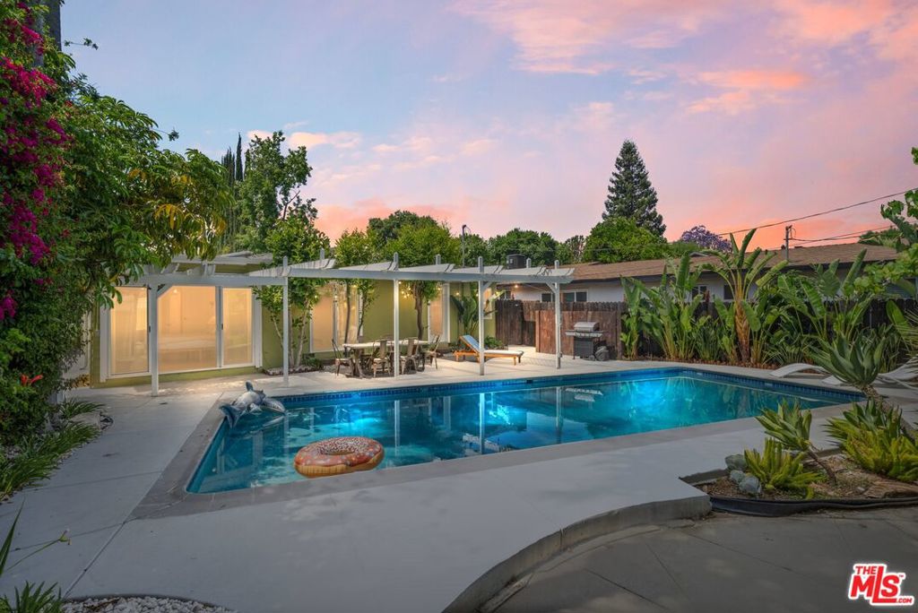 Welcome to this charming Woodland Hills pool home with a guest unit, ideally situated just north of Ventura Boulevard in one of the area's most desirable neighborhoods. Located within the highly sought-after Woodlake, Hale, and El Camino school district, this 3-bedroom, 2-bathroom residence with a detached guest house presents a rare opportunity for both families and investors. Step inside to discover a recently remodeled kitchen featuring granite countertops, all-new cabinetry, and stainless steel appliances. The home's stylish interior includes wood flooring, new windows, and a cozy living room with a fireplace that creates a warm, inviting atmosphere. The flexible floor plan offers thoughtful separation, with two bedrooms and a full bath on one side of the home, and a third bedroom currently used as an office leading to a spacious 400 sq ft step-down family room. Complete with its own bathroom, this versatile space is perfect as a family room, media room, or easily transformed into a luxurious primary suite with en suite bath. The detached guest unit includes a bedroom, bathroom, and an expansive bonus room that can serve as an additional bedroom, studio, office, or creative space. Outside, the private backyard oasis is the true showstopper. A fenced 20' x 40' pool, lush tropical landscaping, and a grassy lawn set the scene for ideal indoor/outdoor California living. Whether entertaining guests or unwinding in the sun, the backyard delivers the perfect blend of beauty and function. All of this just moments from shops, dining, Topanga Westfield, The Village, parks, and convenient freeway access this home truly has it all.