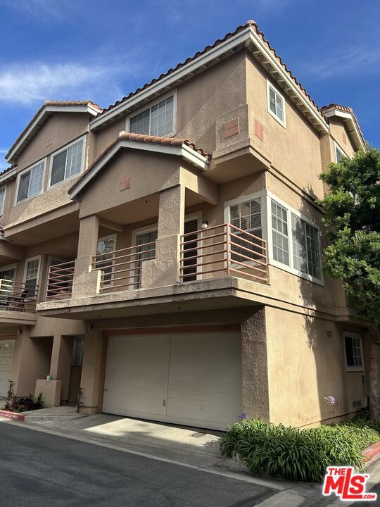 A charming tri-level Townhome in Hawthorne! Greeted by a quaint entryway, this attached corner home offers a bright 3-bedroom, 2.5-bathroom, within 1,352-sqft of living space. Enjoy an open living room and dining room adjoined by gorgeous hardwood flooring throughout. The neat kitchen includes granite countertops complimented by ample cabinetry and stainless-steel appliances. The second level houses a half-bathroom enhanced with granite countertops plus a private balcony just off the living room that's a great addition of entertainment space. Up to the third level, enjoy perfectly airy and spacious bedrooms all complete with built-in closets enhanced with mirrored sliding doors and high ceilings. The primary bedroom includes an en-suite split bathroom providing a dual sink vanity with a granite countertop. The home includes ample storage throughout along with direct garage access to the 2-car garage featuring washer/dryer hookups accessible from the first-floor entryway. Residing within a clean, well-lit, gated community, residents can enjoy the sparkling glittering pool that's perfect for cooling off during a hot summers' night. Minutes from Los Angeles Air Force Base, Northgate Market, El Camino College, Target, parks, schools, dining options, and more!