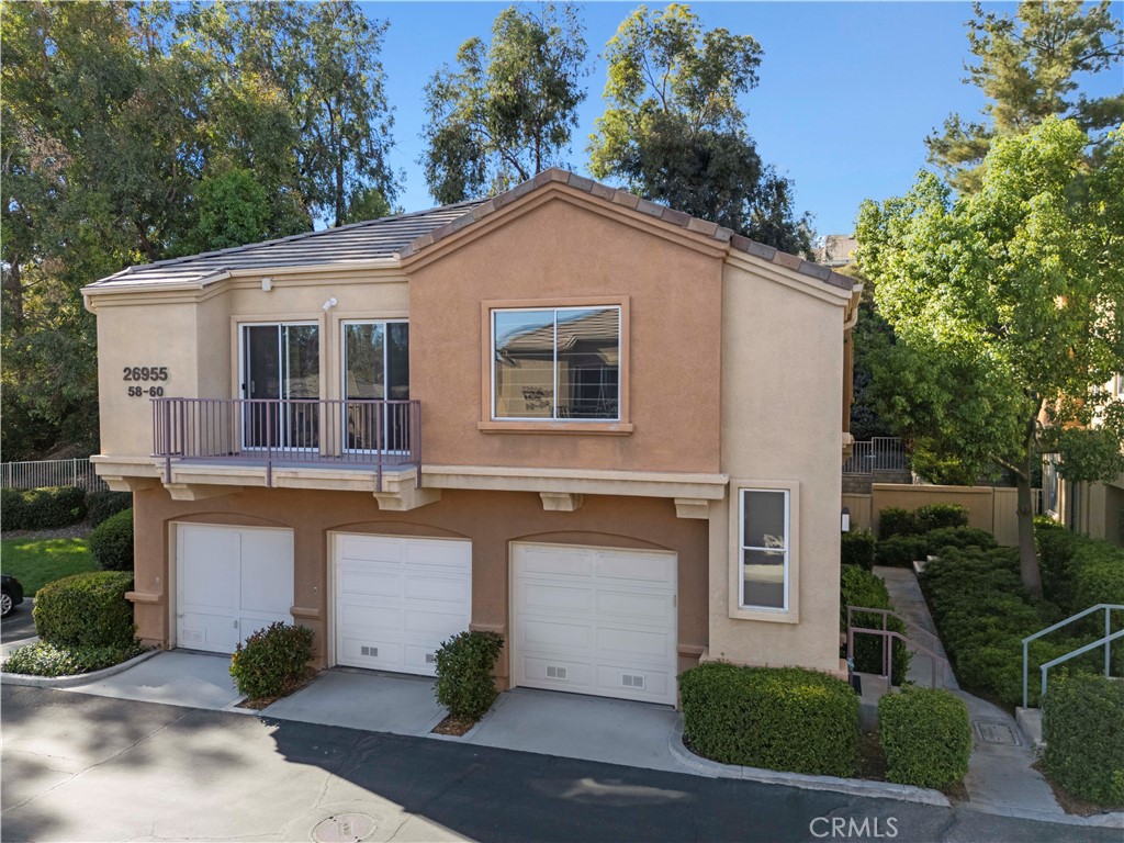 Stunning move-in ready townhome in the popular Rose Arbor community of Valencia Northbridge! This beautifully updated 2-bedroom, 2-bath home features wood-like laminate flooring, designer interior paint, healthy HVAC system, recessed lighting, ceiling fans, and custom blinds throughout. The light and bright open layout includes a gorgeous kitchen equipped with stainless steel appliances, Corian countertops, an under-mounted sink and faucet, recessed and accent lighting, and ample cabinetry. Upstairs, the spacious primary suite offers high ceilings, a large paneled-door closet, a ceiling fan, and peaceful greenbelt views. A generous secondary bedroom, full bathroom, and convenient linen storage complete the upper level. Enjoy the private, low-maintenance backyard with concrete patio, decorative rock landscaping, and artificial turf—perfect for outdoor relaxation. Additional highlights include an attached garage with tile flooring, a second detached garage, and in-unit side by side laundry. The HOA covers water, trash, patrolled security, common area maintenance, and access to the community pool and spa. Ideally located near award-winning schools, Valencia Town Center, shopping, dining, scenic paseos, and just minutes to the freeway. No Mello Roos!
