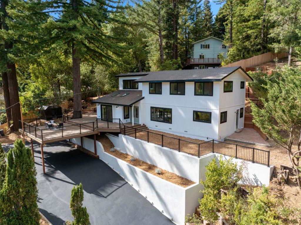 Fully refreshed from the ground up, this stunning 4-bedroom, 3.5-bath modern farmhouse offers style, comfort, and mountain living. Every detail has been thoughtfully designed, from the gorgeous finishes to the open-concept floor plan that brings everyone together. The chefs kitchen flows seamlessly into the living room, making it the heart of the home, while large windows and sliding glass doors frame sweeping mountain views. Venture outside onto the expansive south-facing deck perfect for entertaining or relaxing with a glass of wine as the sun sets over the ridgeline. With over half an acre of usable land, you'll have space to create your dream garden, add an ADU for rental income, or design the ideal multi-generational retreat. Located just minutes from charming downtown Boulder Creek, you're close to everything, locals favorite Scopazzis, boutique shops, and endless outdoor recreation. Whether its hiking through the redwoods, mountain biking world-class trails, or commuting to Silicon Valley via major thoroughfares, this home keeps you connected while offering a peaceful mountain escape.