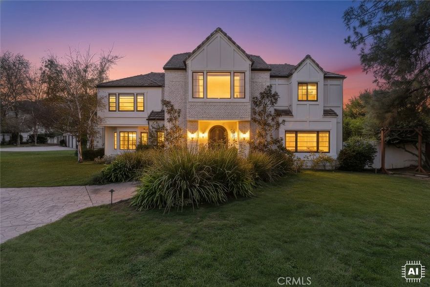 Nestled on over an acre in one of Agoura Hills’ most desirable cul-de-sac enclaves, this impressive residence spans approximately 4,726 square feet with 5 bedrooms and 4 baths. 

A grand, light-filled foyer greets you as you enter, flowing into a formal living room and framed by soaring ceilings and generous windows. Beautiful hardwood, stone, and tile finishes run throughout. The formal dining room includes a butler’s pantry for convenience. In the heart of the home, the chef’s kitchen features stainless appliances, granite countertops, a walk-in pantry, and a cozy breakfast nook that opens seamlessly to the family room, complete with a stone fireplace and views out to the yard.

On the main floor, there is also a guest bedroom with an en suite and a dedicated office or study, perfect for work-from-home needs. Upstairs, the primary suite offers a private balcony, serene views, a stacked-stone fireplace, and a luxurious spa-style bath with a large walk-in closet, soaking tub, and separate shower. Two additional well-sized bedrooms complete the upper level.

The outdoor living experience is exceptional: expansive patios and stone decking ideal for entertaining, a built-in BBQ center, brick-accented swimming pool and spa, lush gardens, and expansive lawns. A fully lighted north/south tennis court and an oversized 4-car garage round out the amenities.

With its enviable location, elegant appointments, and vast outdoor space, this property embodies refined Southern California living.