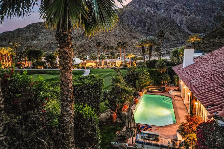 Located in the picturesque heart of The Enclave, this meticulously crafted Spanish estate embodies timeless elegance and a resort-inspired lifestyle. Offering breathtaking South Mountain views and the allure of starry desert nights; this home channels the enchanting ambiance of the nearby La Quinta Resort. From the moment you arrive, the hand-carved double entry doors and adobe-style stucco invite you into a world of bespoke craftsmanship. The Spanish clay tile roof, Saltillo tile blending indoor and outdoor spaces, and wood-beamed ceilings adorned with chandeliers create a sophisticated yet welcoming retreat.  Every detail has been thoughtfully curated, including hand-painted French doors that lead to a serene pool and spa, set amidst lush, mature landscaping for ultimate privacy. The patio offers the perfect vantage point to enjoy the beauty of the Mountain Course.  This residence boasts three generous bedroom suites, each with a private en-suite bath, ensuring comfort and privacy for all. The graciously sized kitchen features abundant counter space, ideal for culinary pursuits, while the stately living and dining rooms provide an impressive setting for entertaining. A cozy family room with a versatile den/office area and a three-car garage with additional golf cart parking complete this thoughtfully designed home.  Residents enjoy unparalleled access to world-class dining, shopping, spa services, tennis, and championship golf.