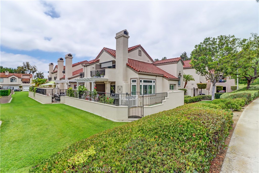 Welcome to the most sought-after floor plan in the community of Coral Gardens - a beautifully upgraded TRUE 3-bedroom, 3-bathroom END UNIT condo with the rare advantage of NOBODY LIVING ABOVE OR BELOW YOU. Ideally situated in a QUIET INTERIOR LOCATION away from street noise, this home is surrounded by a lush greenbelt and just a short walk to scenic Lake Mission Viejo. This private end-unit offers THREE DISTINCT OUTDOOR LIVING SPACES: a spacious enclosed front courtyard, a large wraparound back patio and a generous-sized balcony off the primary suite — perfect for enjoying the spectacular 4th of July fireworks from the comfort of home. The back patio has gate access to the surrounding greenbelt area, is partially covered, has a tranquil fountain, rose bushes and a brand-new patch of turf ideal for kids or pets. This floorplan offers a MAIN FLOOR BEDROOM AND FULL BATHROOM - perfect for guests, multi-generational living, playroom, or a home office. Each bedroom in the house has exclusive use of a full bathroom. The living room is airy with its vaulted ceilings and large windows offering plenty of space to accommodate formal dining or simply enjoy as a spacious great room. The kitchen features quartz countertops, stainless steel appliances (gas range, refrigerator, and microwave), and a breakfast bar. Upstairs, the spacious primary suite opens up to a large balcony with an attached sunshade. The Primary bathroom has dual sinks, a walk-in shower and spacious closet space. A secondary bedroom and full bathroom complete the upper level. Additional upgrades include NEW WINDOWS AND SLIDERS THROUGHOUT (3 years old), WATER SOFTENER (2 years old), PLANTATION SHUTTERS, NEWER HVAC (2013), recessed lighting, crown molding, tile flooring, custom fireplace doors, and the ENTIRE HOME HAS BEEN REPIPED WITH PEX (2015). The attached 2-Car Garage has an epoxy-coated floor and plenty of storage spaces to keep you organized. Front loading washer and dryer is included, and you will love the custom & functional laundry sink/storage area next to it. The Coral Gardens community is meticulously maintained and offers fantastic amenities, including a sparkling pool, two spas, two tennis courts, and a grassy field perfect for picnics and outdoor recreation. As a homeowner, you'll also enjoy exclusive MEMBERSHIP TO LAKE MISSION VIEJO with access to boating, swimming, 2 clubhouses, picnic areas and a variety of community events, such as the Summer Sunset Concert Series.
