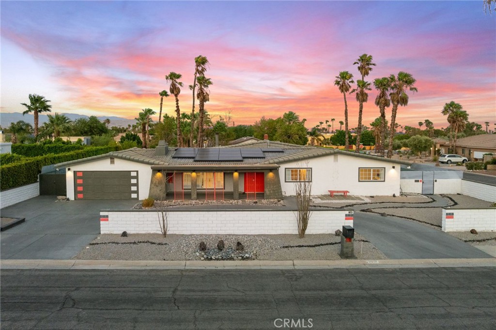 Discover the epitome of desert luxury with this fully furnished Palm Springs retreat, where retro charm meets modern elegance. Nestled on a sprawling 12,197 sq ft corner lot, this single-story gem offers breathtaking mountain views and mesmerizing desert sunsets, creating a serene backdrop for your everyday living or weekend getaways. Step inside to experience a seamless blend of style and functionality. The heart of the home is a beautifully remodeled kitchen, boasting sleek stainless steel appliances (new upgraded range and dishwasher), granite countertops, and an upscale moveable island prep area perfect for culinary adventures. A spacious pantry ensures ample storage, while the open layout invites effortless entertaining. This home features two luxurious primary suites, each with its own elegant ensuite bathroom. Two additional bedrooms and a full bath with convenient backyard access provide flexibility and comfort for family and guests. Enjoy the convenience of indoor laundry and the warmth of two inviting fireplaces. Every detail has been thoughtfully curated, from the unique doors and shiplap-lined closet to the striking painted wooden beams, barn doors, and built-in bookshelves. The primary suite is a personal sanctuary, complete with a painted sky ceiling that evokes a sense of tranquility. The private backyard oasis is a true highlight, offering a sparkling salt water pool with a soothing waterfall spillway, a rejuvenating spa, and a covered outdoor lanai perfect for al fresco dining. Gather around the firepit for cozy evenings, or challenge friends to a game of ping pong or corn hole in the expansive space perfect for entertaining. This home is not only beautiful but also eco-friendly, featuring FULLY OWNED 36 Tesla Solar Edge Inverter solar panels with 2 Tesla powerwalls, nest thermostat and a NEW ROOF & underlayment (2021), ensuring energy efficiency and sustainability. Not to mention NEW pool pump and heater.Located just 10 minutes away from downtown Palm Springs, embrace the ultimate desert lifestyle in this Palm Springs oasis where retro sophistication and modern amenities come together in perfect harmony. Per the city, NO STR waitlist for new permits!