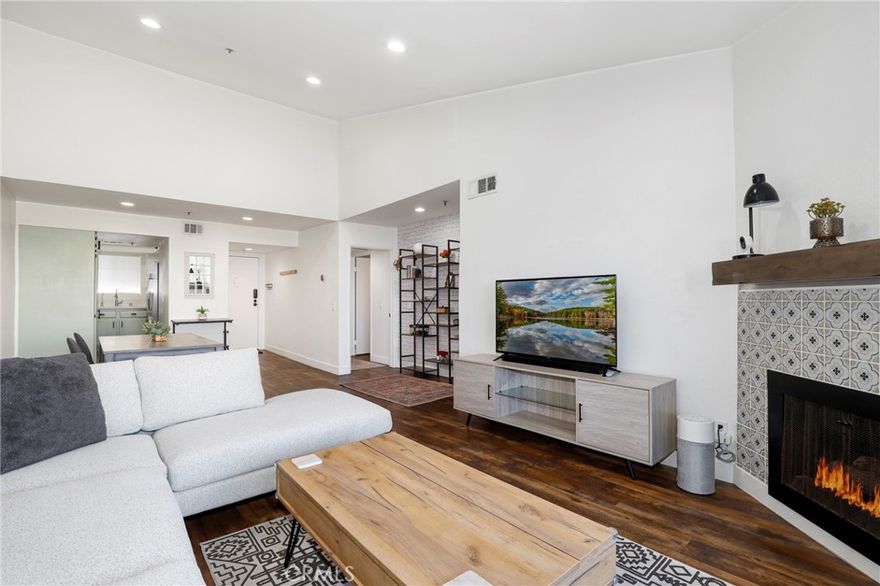 STUNNING TOP-FLOOR CONDO WITH VAULTED CEILINGS & OPEN VIEWS. Welcome to 6545 Reseda Blvd #19, a beautifully upgraded 2-bedroom, 2-bathroom condo offering style, comfort, and peace of mind. This home features soaring vaulted ceilings, abundant natural light, and sweeping mountain and city light views. Inside, the living and dining areas feel open and inviting with newer, high-quality wood/laminate flooring, recessed lighting, and a decorative gas fireplace that adds character and warmth. The modern kitchen showcases sleek Quartz countertops, stainless steel appliances, and a built-in reverse osmosis water filter with pure alkaline water at the tap. A new premium full-capacity washer and dryer are tucked neatly into a dedicated laundry closet. The primary suite provides a private retreat with two large closets and a remodeled en-suite bathroom featuring a dual-sink Quartz vanity and a walk-in shower with a dual shower system, including a rainfall shower head. The second bedroom offers flexibility for guests, a home office, a nursery, or bonus space. Step outside to your private balcony, where open views create an enhanced sense of tranquility — the perfect spot to enjoy morning coffee or evening sunsets.  Additional highlights include built-in smart features such as the latest Google Nest energy-saving thermostat, smart light switches that connect to your phone for control by voice or remotely, and a keyless touchpad front door lock. The home also offers a recently serviced central air and heating system for year-round comfort. For added convenience, enjoy two side-by-side parking spaces with storage shelving in a remote-controlled gated subterranean garage, a secure intercom system with direct phone access for visitors, a community elevator, and extra guest parking. In addition, the community recently completed extensive renovations — including all new roofs and gutters, fresh exterior paint, and full balcony and walkway reconstruction — ensuring a refreshed, upgraded, and well-maintained property. Best of all, this condo sits directly across from Reseda Park, with its serene lake, playgrounds, sports courts, baseball fields, community center, picnic areas, public swimming pool, and more — endless recreation at your doorstep. Just minutes from CSUN, Pierce College, shopping, and dining, this home combines modern upgrades with unbeatable convenience. A rare top-floor opportunity in a prime location — stylish, refreshed, and truly turnkey ready!