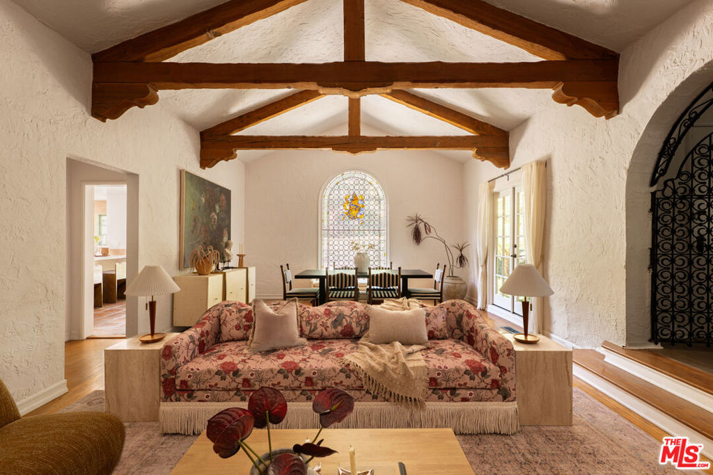 Tucked behind tall trees and a private gated entrance in the heart of the Hollywood Hills, this charming 1920s Spanish-style home is full of character and soul. From the moment you step inside, you'll notice the authentic details that make this place so special carved wood beam ceilings, classic Spanish tiles, warm terracotta and hardwood floors, and French doors that open up to lush gardens and peaceful outdoor spaces. With 4 cozy bedrooms and 3.5 bathrooms, the home strikes the perfect balance between vintage charm and modern comfort. Every room feels welcoming and lived-in, with thoughtful updates that still honor the home's original style. Up above the main house, there's a spacious flat grassy area with raised veggie beds ideal for hosting friends, lounging under the stars, or enjoying quiet afternoons surrounded by nature. Multiple patios and garden nooks make outdoor dining and relaxing feel like second nature. There's also an attached garage for extra storage and updated systems throughout the home, so you can enjoy the old-world charm without any of the headaches. This is a rare find: a warm, romantic retreat that captures the essence of classic Hollywood with all the conveniences of today.