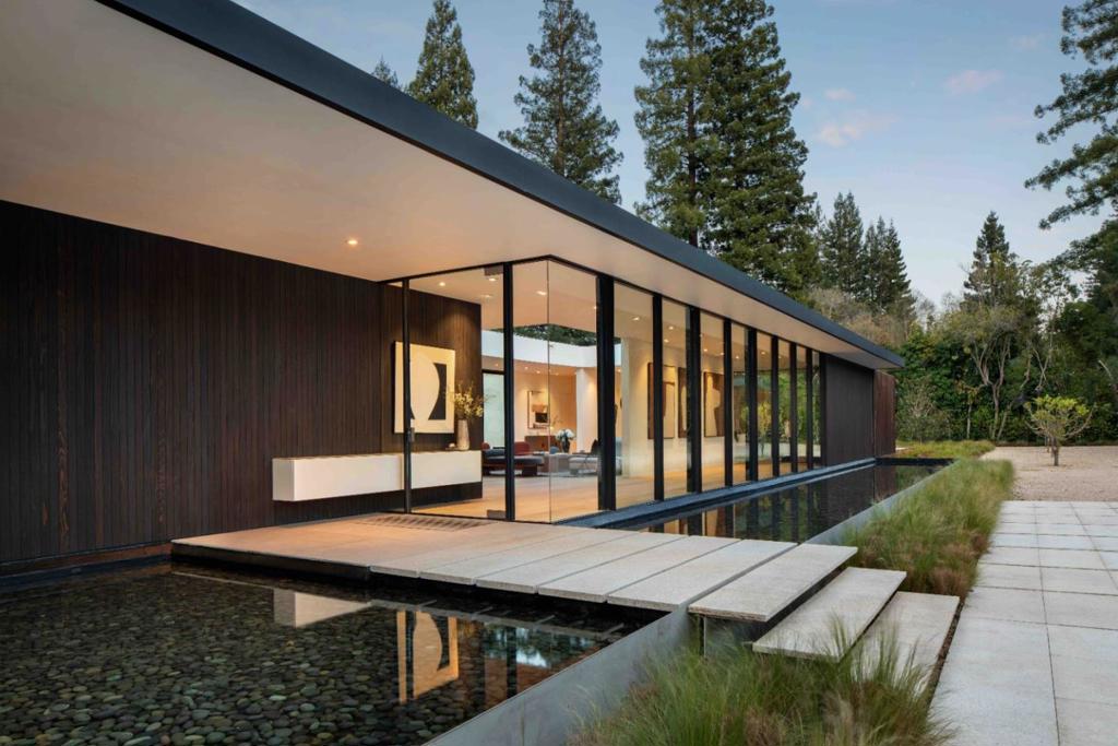 Flawlessly integrated form and function are epitomized in this home, an engineering marvel and a masterful expression of modernism. Precision craftsmanship showcases the design of award-winning architect Curt Cline of Modern House, creating a clear aesthetic vision that is both bold and graceful. His design principles, Blur the boundaries between the natural world outside and the created world inside, have been artfully achieved at this home. Cline further states, and has incorporated here, Maximize the connectivity of the interior living space and the exterior space, both visually and actually. The entire design revolves around the use of glass with entire walls that fully retract and the true marvel a retractable glass ceiling in the living room. The restrained design incorporates a Studio Becker kitchen, 2 offices, 4 main-level bedroom suites, plus a lower-level recreation room with golf simulator, a wine cellar, and a fitness center. The selection of finishing materials throughout is made with a refreshingly unique approach, employing sleek materials that are decidedly avant-garde. Adding the finishing touch to this architecturally significant home are multiple wraparound outdoor living spaces and a pool creating the quintessential California lifestyle