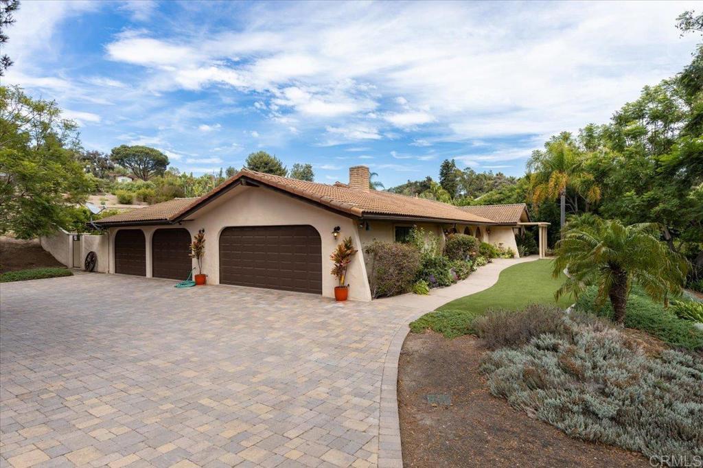 Tucked away in one of Olivenhain’s most coveted and private enclaves, this expansive .62-acre lot offers endless possibilities to create your ideal outdoor lifestyle. The single-story residence features 3 bedrooms, 2 bathrooms, and 1,938 square feet of tranquil country living, all with no HOA. It’s one of the best-priced opportunities in Olivenhain for a property of this size and setting. With room to add a pool, outdoor kitchen, or even a pickleball court, this is your chance to make the Olivenhain dream a reality. Inside, thoughtful updates include stylish LVP and tile flooring. The home offers a welcoming formal living and dining room, along with a cozy family room anchored by a fireplace. Car enthusiasts, hobbyists, and creatives alike will appreciate the exceptional garage and flex space. In addition to a traditional two-car garage with built-in cabinetry, you’ll find an extra two-car bay—perfect for a workshop, home gym, art studio, or car collection. This versatile setup ensures space to create, work, and play without compromise. All this comes with close proximity to shopping, scenic horse and walking trails, downtown Encinitas, freeway access, top-rated schools, and just 3.7 miles to the beach.