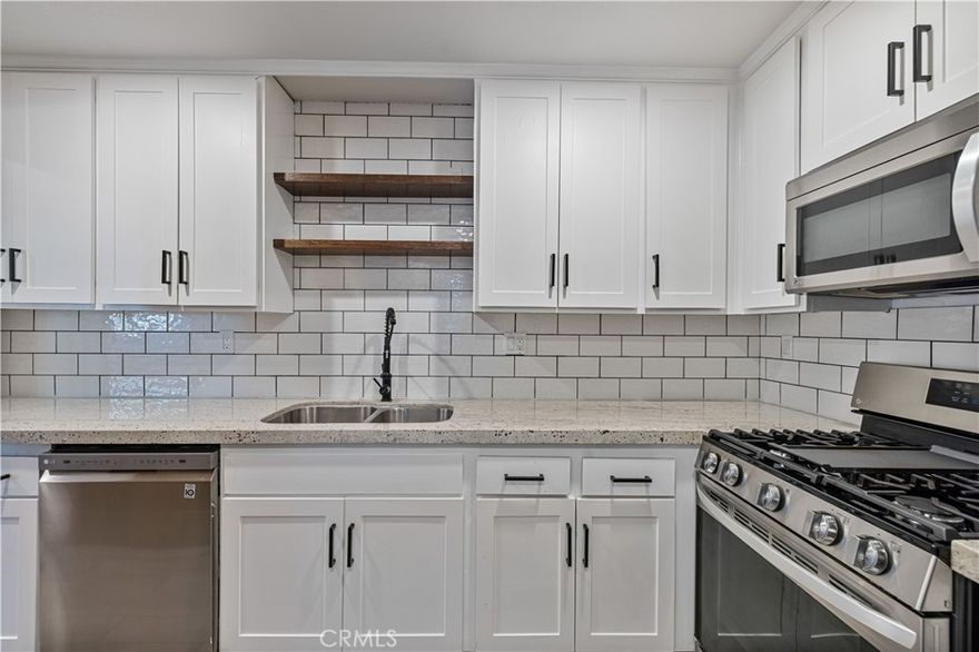 Welcome home to this beautifully updated, MOVE-IN READY, end-unit condo boasting 3 bedrooms, 2.5 bathrooms, back patio, a detached 2 car garage, and PLENTY OF UPDATES over the last few years! As you enter into the spacious living room, plantation shutters and newer recessed lights help it show light and bright. The fireplace serves as a beautiful focal point adding warmth and comfort to the space, while your adjacent dining area features a stunning wood-paneled accent wall illuminated by a newer modern light fixture. Your kitchen has been tastefully updated with wood-like tile flooring, white granite countertops (matching in all bathrooms), newer cabinetry, matte black hardware and coil spring gooseneck sink faucet, subway tile backsplash, floating shelves, a pantry with farmhouse style bi-fold barn doors, and stainless steel appliances that are all just a few years old (fridge included)! You also have a half bath downstairs with floating shelves against a black accent wall. The back slider opens up to the spacious patio featuring string lights, a utility sink, and access to your 2 car garage. Head upstairs to find all 3 bedrooms with newer ceiling fans, your laundry area (washer and dryer included), and 2 more bathrooms. Your primary suite has vaulted ceilings, a stunning black shiplap accent wall, two closets, and a walk-in shower. Your NEWER AC UNIT is only a few years old and the water heater replaced just within the last several months. Your HOA includes a pool, tennis court, and trash is included. Located near plenty of shopping centers, eateries, parks, Castaic Lake, the Castaic Sports Complex, Aquatic Center, and just a hop away from the 5 freeway, you're close to everything so come make this your own while you can!