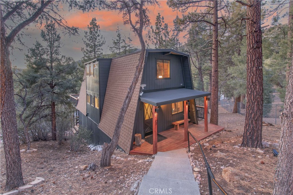 Tucked away among the pines, this beautifully renovated mountain escape offers the perfect blend of style, comfort, and versatility. Ideal as a vacation home, income-producing rental, or year-round residence, the property welcomes you with a charming path leading to the front door. Inside, the remodeled kitchen shines with newer premium appliances and flows seamlessly into the inviting living area, anchored by a striking natural stone fireplace. A wall of French doors frames sweeping sunset views and opens to an expansive, refinished deck—an ideal setting for summer parties and al fresco dining. Upstairs features two refreshed bedrooms and a beautiful shared bath, while the lower level offers a spacious bonus/game room or extra bedroom with its own spa-like bathroom, plus a separate laundry area. Sliding doors here lead to a private second deck surrounded by trees. Fully furnished and set on an 11,700 sq ft lot, this turn-key retreat is ready to enjoy from day one. Call today to schedule a showing!
