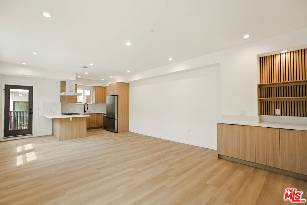 Step into Unit 1842 1/2 a stunning, brand-new tri-level townhome offering three spacious bedrooms, three-and-a-half bathrooms, and a dedicated office or flex space perfect for remote work, a home gym, or a creative studio. Designed with clean modern lines, abundant natural light, and premium finishes, this home blends contemporary elegance with thoughtful functionality.The main level showcases an open-concept layout anchored by a designer kitchen featuring quartz countertops, custom wood cabinetry, stainless steel appliances, and a statement island ideal for both cooking and entertaining. Multiple private balconies, wide-plank flooring, and high ceilings create a seamless indoor-outdoor flow for relaxed living and hosting.Each bedroom includes its own en-suite bath for maximum privacy, while a sleek powder room serves guests. Additional highlights include in-unit laundry, recessed lighting, central air, and the rare privacy of no shared walls above or below offering the feel of a single-family home within a boutique five-unit community. Perfectly located just minutes from Brentwood, Santa Monica, and major freeways. Price reflects one month free concession already included in the advertised rate.