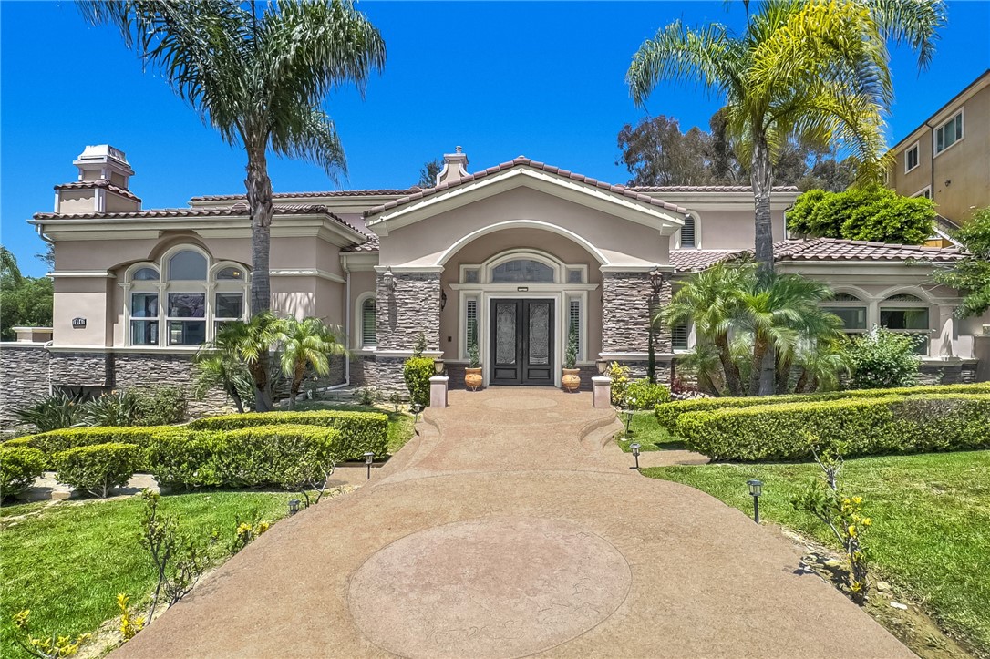 Luxury living at this extraordinary custom home in the famous Whittier Friendly Hills, set behind the 24-hour guard-gated enclave of Friendly Hills Estates. Masterfully crafted and thoughtfully designed, this 5,573 sq. ft. residence offers sweeping views of city lights, coastal sunsets, and lush, rolling landscapes—an exceptional blend of elegance, comfort, and privacy.
Built in 2007, the home features 5 spacious bedrooms and 4.5 opulent baths, including three upper-level en-suites and a main-level guest suite. A private executive office with coffered ceilings and built-in seating adds sophistication to the versatile layout. Resting on over half an acre (28,486 sq. ft.), the estate includes a 5-car garage and a grand motor court accommodating up to 10 vehicles.
Arrive through mature trees and manicured grounds to a dramatic entryway adorned with custom stonework, patterned walkways, and an inviting fountain. Inside, the home impresses with soaring ceilings, architectural columns, arched niches, built-in displays, and hand-selected finishes including travertine floors, designer lighting, and custom window treatments.
The chef’s kitchen is a centerpiece of form and function—featuring professional-grade stainless steel appliances, granite countertops, custom cabinetry, an oversized island with seating, and a walk-in pantry. A charming breakfast nook includes additional built-ins, a wine fridge, and a dedicated wine rack.
Upstairs are three additional bedrooms, the grand primary suite commands breathtaking views, a warm fireplace, a private balcony, a generous walk-in closet, and a spa-inspired bath with a Jacuzzi tub, steam sauna, and dual vanities including a separate makeup station.
Outdoor living is elevated with expertly landscaped grounds, terraced gardens, mature fruit trees, a serene waterfall, and a gazebo perched for panoramic vistas. Reinforced retaining walls, automatic irrigation, and custom wrought iron gates ensure both beauty and durability.
Additional amenities include 3 fireplaces, 3 separate A/C units, expansive wrap-around balconies, and sun-shielding awnings. Every element of this home speaks to superior craftsmanship and an uncompromising standard of luxury.
This is more than a residence—it’s a statement of distinction.
