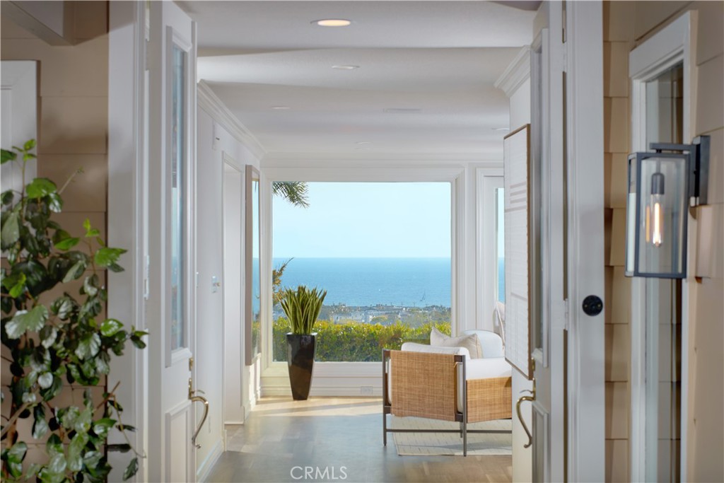 Live life as it is meant to be at this impeccably maintained and upgraded home in Corona del Mar’s desirable Harbor View Hills community. An expansive elevated homesite welcomes panoramic Pacific Ocean, city-light, Catalina Island and sunset views that also encompass the fairways of Pelican Hill and Newport Beach’s pier and harbor. Private and sophisticated, the single-level residence greets guests with a generously sized entry courtyard accented by a tranquil fountain. Double doors open to immediate ocean views that are framed by floor-to-ceiling windows in the living room and a separate den with built-in cabinetry. Leading to a view-enriched terrace, the living room shares a see-through fireplace with a dining room that offers garden vistas. The kitchen shines with Calacatta quartz countertops and full backsplash, stainless steel appliances, courtyard access, a garden window, peninsula, and white cabinetry with a built-in pantry. An open office is located just beyond the kitchen and features a built-in desk and cabinetry. Bright natural lighting accentuates the open design of the home, which extends approximately 3,173 square feet and hosts three bedrooms and three-and-one-half baths, including a casita with separate entrance off the courtyard and a vaulted ceiling. The secondary bedroom is impressively sized and boasts ocean views and a walk-in closet, while the primary suite opens to the view terrace through an elegant retreat and is distinguished by a garden-view shower, two sinks and ample wardrobe space. A 400-bottle wine cooler and epoxy flooring awaits in the attached two-car garage, and an interior laundry room offers a sink, cabinetry and a door leading to the courtyard. Fresh paint joins crown molding, refinished wood flooring, and high-end carpet in select spaces to give the home a sense of timeless elegance. Neighboring Fashion Island, Harbor View Hills is moments from Corona del Mar’s village, Harbor View Elementary School and miles of broad beaches.