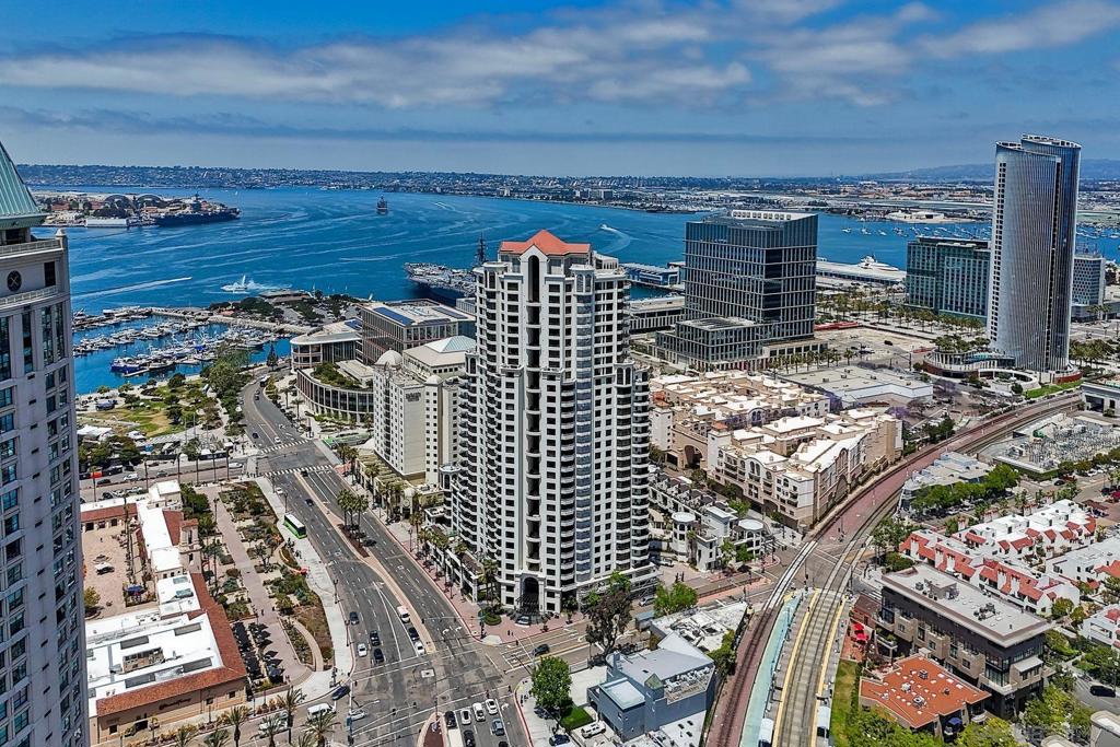 Discover elevated urban living on the 13th floor of Park Place, located in San Diego’s prestigious Marina District. This stunning 1-bedroom + den/office (easily used as a second bedroom) comes with HOA credits and sweeping panoramic views of the bay & city skyline. Inside, this home features elegant cherry wood flooring and custom faux-finish walls throughout the main living areas, bedroom, and den—creating a warm, designer-inspired ambiance. The gourmet kitchen is appointed with stainless steel appliances, a Sub-Zero refrigerator, granite countertops, and a central island with bar seating—ideal for entertaining. The spacious primary suite boasts triple mirrored closets and a luxurious en-suite bath with a soaking tub and walk-in shower. Step onto your private balcony—accessible from both the primary bedroom and the den—to take in breathtaking views morning and night. A second full bathroom provides added flexibility, especially if the den is converted into a guest room or second bedroom. Additional features include two tandem parking spaces, a private storage unit, and access to world-class amenities: a striking lobby, 24-hour concierge, gated security, pool, spa, fitness center, resident lounge, and guest parking. Enjoy resort-style living just steps from Seaport Village, the Convention Center, Petco Park, and Downtown's vibrant dining and nightlife.