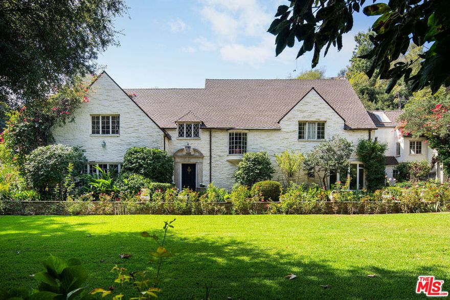 Situated in one of the most prestigious locations in Bel Air, this prime and rare estate sits on approximately 4 acres, surrounded by majestic mature trees that provide exquisite privacy.  Built in 1935 and featured in Architectural Digest in 1938, this English country estate has belonged to the same family for decades.   Behind a gate and driveway, the expanse of the property is significant and the floorplan is timeless. The sublime home offers approximately 6400 square feet of exquisitely detailed and graciously proportioned interior spaces including a formal entry, a gracious dining room, sophisticated living room, and a warm wood-paneled study adjacent to a charming bar.  The second floor encompasses a primary suite and multiple guest bedrooms all with beautiful views of the property. The artful use of terraces, loggias, French doors, and windows create a harmonious flow between indoor and outdoor rooms and grounds. The surrounding manicured gardens lead to a large pool that is positioned perfectly for sun exposure and a lovely pool house.  Beyond the pool and gardens sits an enormous lighted tennis court, a perfect spot for tennis or hosting a large event.   In close proximity to the Hotel Bel Air, only so often does an opportunity to acquire one of the last remaining proper Bel Air and legacy estates come along.