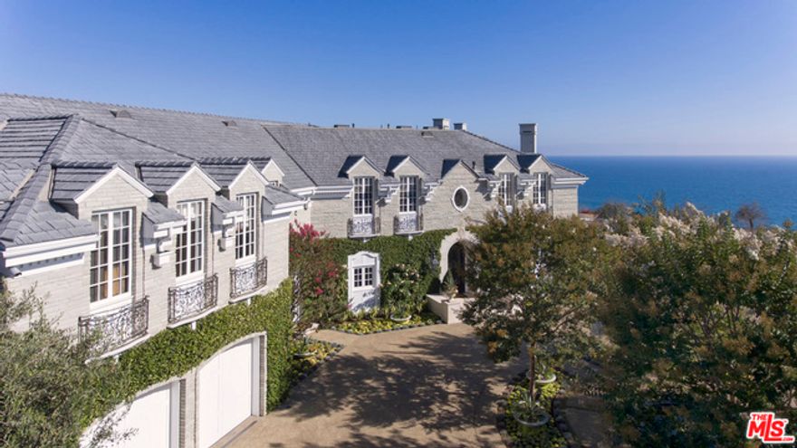 Perched atop the coveted Huntington area of the Pacific Palisades, this oceanside manor is nothing short of presidential - a rare composition of remarkable stonework flush with ivy and backlit by the crimson blue of the Pacific. Entering through wrought iron gates and a palatial motor court, one is greeted by a grand entry hall, guiding you into a medley of impeccably outfitted spaces; a light-drenched living room lined with french doors and crowned with contrasting dark vaulted ceilings, a royal oval dining room fit with hand-painted walls, a generous well-appointed kitchen and a paneled library. Retire to a large master suite with a terrace overlooking breathtaking views of Santa Monica Beach. Lush gardens and a verdant lawn frame the pool and spa terrace, a vast space suited for entertainment or respite. A prestigious edifice amidst the nationally-ranked school district of Huntington Palisades, this home is a bold statement of coastal living at its finest.