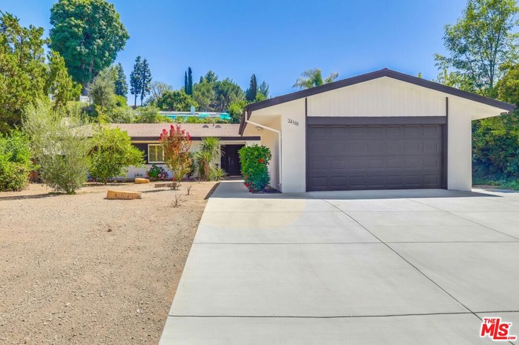 A beautifully reimagined Mid-Century modern gem nestled at the end of a quiet cul-de-sac in the highly sought-after Woodland Hills neighborhood, west of Valley Circle. Fully renovated, single-level living offers 3 generous bedrooms and 2 bathrooms, with 1,936 sq ft of open-concept living space on a spacious 12,051 sq ft lot. Step inside to soaring ceilings and a flood of natural light that flows seamlessly through the bright and airy living areas. A black-brick fireplace adds warmth and texture, while an expansive window and sliding glass doors frame serene views of the yard. Chef's kitchen features sleek black cabinetry, white quartz countertops, stainless steel appliances and a large farmhouse sink. Adjacent to the kitchen is a walk-in pantry and laundry room. The effortless flow between the dining and living areas makes this space perfect for entertaining. Primary bedroom features an ensuite bathroom with double vanity sink, zero slope travertine shower, soaking tub and a walk-in closet. Second bath has a one-of-a-kind Indonesian hand carved limestone sink, travertine tiled shower and floors. Step outside into your private, drought-tolerant yard, where the patio space invites morning coffee or stargazing. Two car garage and a newly cemented 3 car driveway. Don't miss your chance to own this rare find - it truly checks all the boxes.