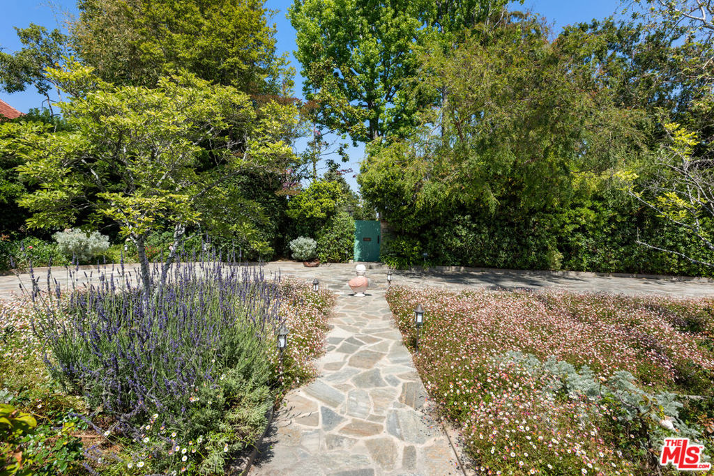 "Magical Oasis." Unparalleled privacy and serenity in this elegant home located behind mature landscaping and a walled enclosure, ideally situated on almost 3/4 of an acre on one of the best streets in the Beverly Hills Flats. Approximately 5,000 square feet, single level with great scale and an effortless floor plan. Chef's kitchen with Viking appliances and breakfast room, formal dining room, and comfortable family room. Primary suite with dual bathrooms and walk-in closets. 3 additional bedrooms and a separate guest house with private entrance.