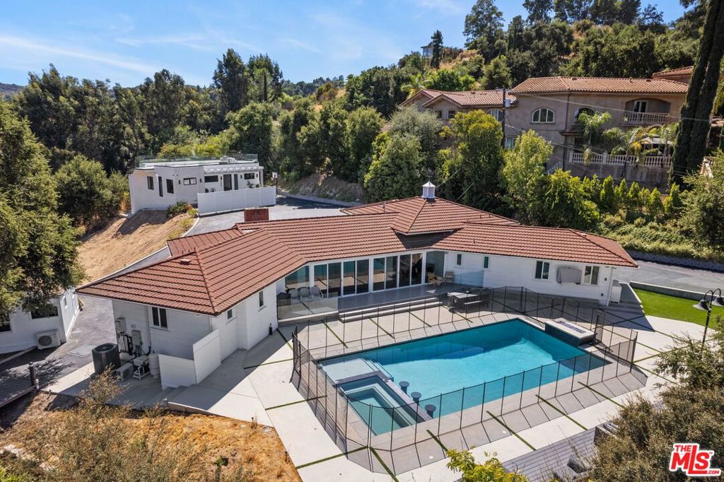 Welcome to this exceptional Tarzana gem! This beautifully updated 4-bedroom, 4-bathroom home offers a perfect blend of luxury and functionality in a sought-after location. Upon arrival, you'll be greeted by lush landscaping and a charming faade that sets the tone for the rest of the property.Inside, the open-concept living areas are filled with natural light, highlighting the modern finishes and elegant design. The spacious living room features a cozy fireplace and large windows, creating a warm and inviting atmosphere. The chef's kitchen is a culinary masterpiece, complete with high-end appliances, sleek countertops, and generous counter space ideal for meal prep and casual dining. Adjacent to the kitchen is a formal dining area, perfect for hosting dinner parties and family gatherings. The master suite is a true sanctuary, featuring a king-sized bed, a private retreat, a walk-in closet, and a luxurious en-suite bathroom with dual vanities, a soaking tub, and a walk-in shower. The additional three bedrooms are equally well-appointed with queen-sized beds, providing comfort and privacy for family and guests. Want a private space to watch movies, you'll love the private entertainment room. Step outside to your own private paradise, where you'll find a sparkling pool and hot tub, surrounded by a spacious deck, ideal for sunbathing and relaxation. Beyond the pool area, the property features a professionally maintained soccer field, perfect for sports enthusiasts and family fun. Additional highlights include a dedicated laundry room, ample parking, EV charging spot, and tons storage throughout. Located in a desirable Tarzana neighborhood, this home offers both tranquility and convenience, with easy access to local amenities, top-rated schools, and major highways. Don't miss the chance to make this remarkable property your own. Schedule a tour today and experience the perfect blend of luxury, comfort, and recreation!