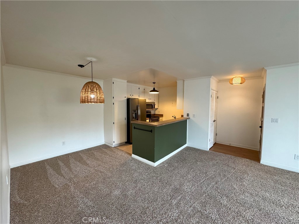Charming 2 bedroom 2 bath upper end unit in Woodside Village with fresh upgrades, including new carpet, laminate wood flooring and fresh paint, along with with included stainless steel refrigerator and updated bathroom fixtures. Open concept floor plan with kitchen open to living room and dining nook. Living room glass slider with built-in dog door brings in abundant natural light, and leads to a private covered balcony with tree-top view offering additional privacy. Oversized primary suite features wall-to-wall closet and ensuite bath. Water, trash & gas are included in the lease, as well as available parking for two cars: one assigned covered carport space with storage cabinet, as well as a permit for one additional unassigned space. Great central location in the complex, with close access to parking area, association swimming pool & spa, clubhouse, as well as communal laundry, all just steps away. Woodside Village enjoys securely monitored & gated access to the community, and is in close proximity to major points of interest such as South Coast Plaza, Segerstrom Center, OC Fairgrounds, and easy access to John Wayne Airport and major freeways.