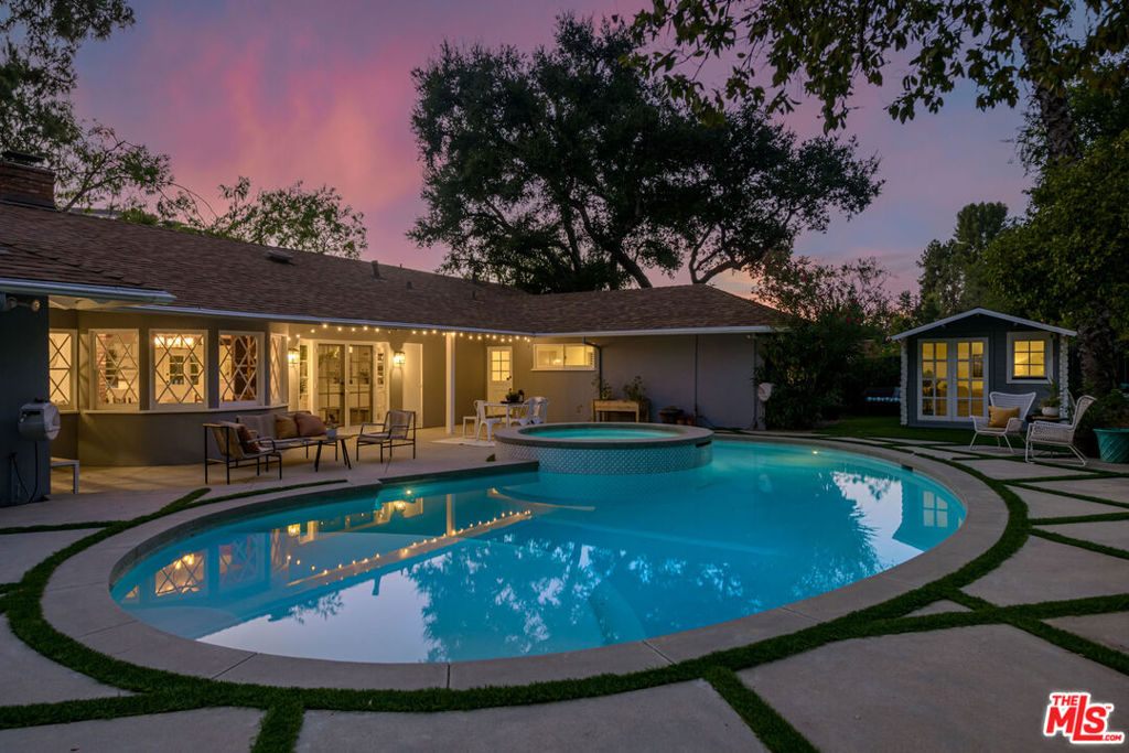 Tucked away up a long driveway, south of Ventura Boulevard sits this immaculate single-story residence on a 20,000+ sq ft lot. Located in the coveted Lanai School District with easy access to the city and the valley, this 3BD + Office home's sophisticated design, high-end upgrades, and unique charm provide the perfect balance of relaxation, style and comfort. The grounds include a detached outside space perfect for a second office or gym and the additional office could easily become a 4th bedroom. Newly renovated with a chef's kitchen featuring Wolf and Kitchen Aid appliances, custom cabinetry, bright living spaces, and a new sparkling spa and pool. Off the primary suite sits a large private side yard perfect for a sitting area or dog run. The spa-like en-suite bathroom offers high-end fixtures, a spacious dual vanity, classic marble touches and a dual head, large shower. Two additional bedrooms provide generous closets, ideal for a family or hobbies. The office/guest room adapts as a home office, guest suite, or studio with treetop views. The backyard, a private paradise centered around an oversized pool and spa, is framed by lush landscaping and multiple areas for dining al fresco. Here you will find the detached space overlooking the beautiful outdoor oasis. The finished epoxy-coated two car garage includes custom cabinetry, insulation and an attic space. Minutes from shops, dining and a top rated school, this home offers quiet seclusion without sacrificing convenience.