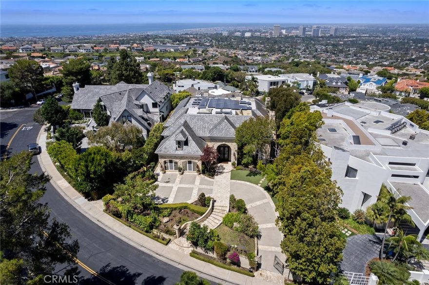 Located within the prestigious guard-gated community of Harbor Ridge and crafted by world-renowned builder Tony Valentine, 5 Ridgeline evokes the elegance of a grand European estate. Showcasing panoramic views of the Pacific Ocean, Catalina Island, Rancho Palos Verdes, and twinkling city lights, this residence offers an unmatched blend of timeless sophistication and modern luxury. Upon entering, you're welcomed by soaring two-story ceilings and a sweeping staircase leading to the expansive primary suite and four generously sized en-suite bedrooms. Designed for grand-scale entertaining, the home features multiple formal and informal living areas, a gentleman’s office, game room, a fully equipped gym with steam shower, and a 10+ car garage. The meticulously landscaped backyard is a private retreat, offering multiple seating areas, a large pool, and a palatial koi pond. Additional highlights include solar power, two laundry rooms, and an ideal location just moments from the 73 Toll Road, world-class shopping and dining at Fashion Island, and Orange County’s most prestigious beaches.