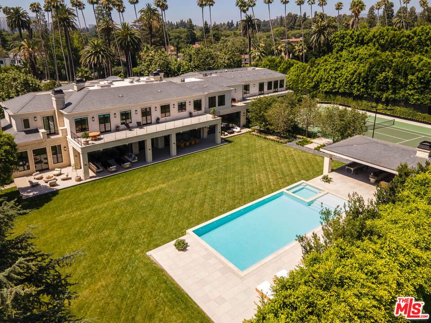 Reduced over 15 Million. Unsurpassed perfection in the city of Beverly Hills. Nestled behind a grove of 30 year old trees and down a 130-foot long bluestone driveway, this newly finished estate is a masterpiece of architectural design. Impeccably styled, the home spans approximately 17,000sf on one of the largest flat lots north of Sunset. It boasts features such as Riviera Bronze doors/windows, decadent imported stones and woods, and meticulously hand-plastered walls and ceilings. Automated walls of steel and glass seamlessly blend the interiors with a sprawling backyard that's nothing short of breathtaking.  Upon entering through a sleek piano-black lacquered door, we are greeted by a 33-foot high foyer, crowned by an art deco bronze skylight. The main level offers a mocha ash stained library, cinema-grade theater, massive living room showcasing one of the most stunning marble bars you will ever see in a private residence, lavish dining room, five powder rooms, a dream kitchen combined with a breakfast area and family room, dedicated catering kitchen, wine room, a lower-level bedroom suite and an office for security personnel and property management. The upper level indulges with a sprawling 2,000sf primary suite, featuring a separate living room and bedroom, twin spa-inspired bathrooms clad in oversized marble slabs, vast closets, and a 900sf private balcony overlooking the sprawling and extremely private grounds. Also upstairs are four generously sized bedroom suites all with walk-in closets, a family room adorned with bespoke stained cabinetry, and an athlete's dream gym complete with spa bath and massage room. The park like outdoor space rivals the finest resorts with its vast lawns, cabana offering outdoor living and dining, a full-service outdoor kitchen, two powder rooms, an outdoor shower, a zero-edge French blue plastered pool and spa, meandering bluestone pathways, and a fully lighted championship size tennis court. Additional amenities include a Crestron smart home system, six-car garage, elevator, marble clad dog station, advanced security system, and six fireplaces. All just steps away from the Beverly Hills Hotel. Viewings available for pre-qualified clients only.
