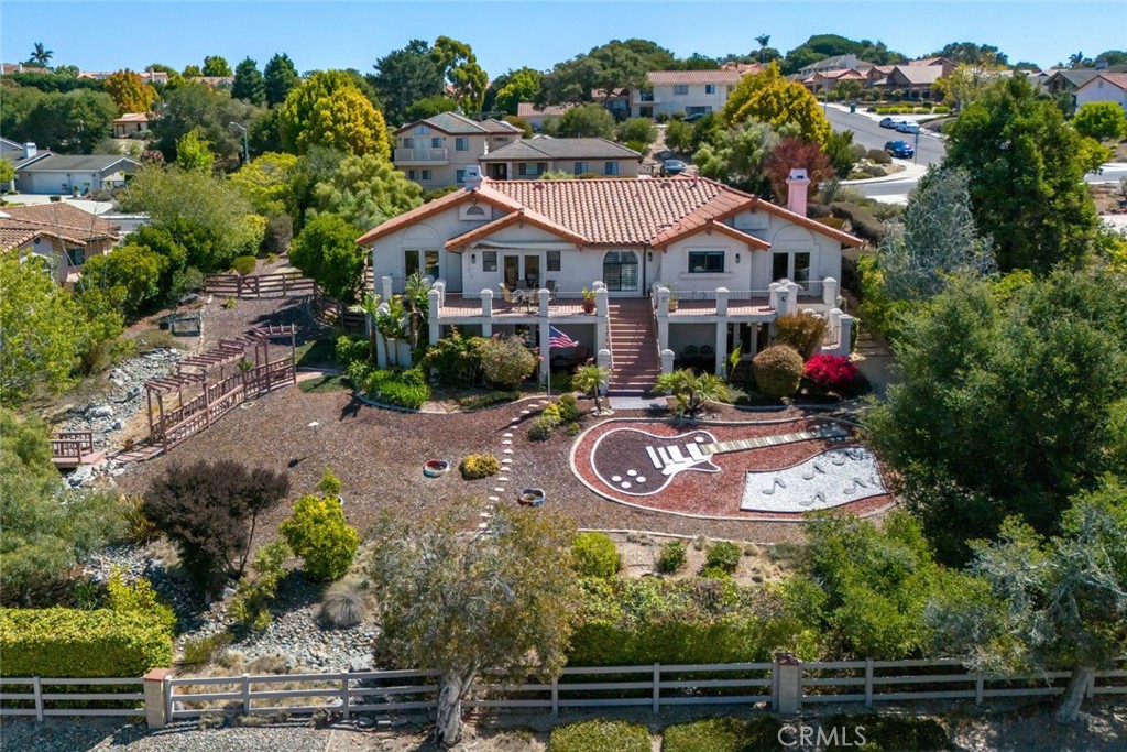 Welcome to Rancho Grande in East Arroyo Grande! This beautiful home features spacious living areas, a thoughtfully designed floor plan, and a landscaped backyard perfect for entertaining. Ideally located near the Village, top-rated schools, parks, and just minutes from the beach—offering the best of Central Coast living.” This 5 bedroom, 4 bathroom SOLAR home offers spacious main level living on almost half-acre lot with ocean views and multiple outdoor entertaining spaces. The main level showcases soaring ceilings, lots of windows and natural light, engineered hardwood floors, and grand arched details. Formal living and family rooms each feature fireplaces and sliding or french doors to large viewing deck area, while the light and bright kitchen is complete with quartz countertops, breakfast bar and plenty of storage. Four bedrooms are conveniently located on this level, including a remodeled guest bath with travertine tile walk in shower and tile floors. The primary suite offers a walk-in shower, soaking tub, dual vanities, walk-in closet, private water closet and French doors that open to the back patio. The lower level provides incredible flexibility with a huge bonus area perfect for a second living room, multi generational living or guest quarters. A second primary suite with French doors and an oversized walk-in closet adds to the versatility, while the soundproof insulated music room is ideal for musicians or creatives. Outdoor living is a dream with mature landscaping, a meandering rock stream with water feature, multiple patios for alfresco dining, a Jacuzzi spa, and views of the Pacific. Whether hosting gatherings or enjoying peaceful mornings with coffee, the setting is unmatched. Additional features include Owned solar for energy efficiency, dedicated laundry room with ample cabinetry, two-car garage, main level living with four bedrooms upstairs and multi-generational potential downstairs. Located in the highly sought-after Rancho Grande neighborhood of East Arroyo Grande, this home blends timeless Mediterranean style with modern amenities, offering both elegance and comfort in a premier location. Located down the street from Rancho Grande park, shopping, Trader Joes, eateries, coffee shops, movie theatre and medical facilities.