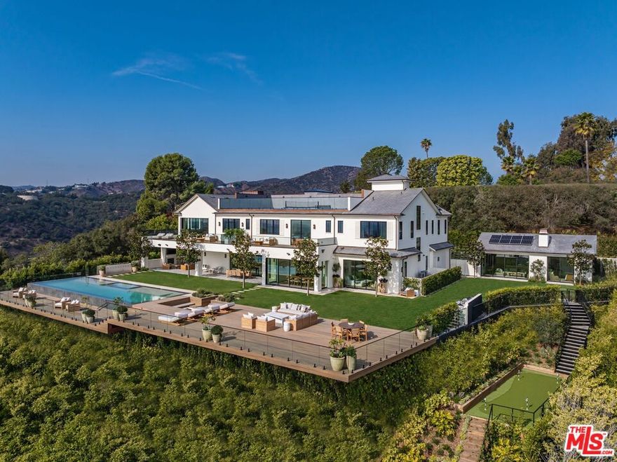 Where Old World Bel-Air meets modern-day design and function, this newly completed 2025 White Brick Traditional sits atop a nearly one-acre promontory with sweeping views from DTLA to the Pacific. A true trophy estate, this residence offers an unrivaled blend of grandeur, privacy, and contemporary livability. Designed by AMG Capital with interiors by Morrow & Co. for the most discerning buyer, the estate spans approximately 15,520 square feet, featuring eight en-suite bedrooms and 12 bathrooms, seamlessly merging timeless elegance with state-of-the-art amenities. The expansive primary suite boasts soaring ceilings, dual walk-in closets, a spa-inspired bath, and a private balcony overlooking the city and ocean. Walls of glass open to resort-like grounds, showcasing an infinity pool and spa, multiple outdoor living areas, and one of the finest pickleball courts in Los Angeles, offering panoramic views over all of Los Angeles. The lower level is an entertainer's dream, complete with a full bar, golf simulator, home theater, and an indoor/outdoor wellness center featuring a gym, sauna, steam room, and massage area. A detached guest house provides private accommodations with a full kitchen and living space. A two-car garage and an additional auto gallery, gated driveway with a guard booth, and lush, manicured landscaping complete this estate's unparalleled offering. Experience the pinnacle of Bel-Air luxury--a home where world-class design, breathtaking views, and resort-style living converge in one of the city's most coveted locations.