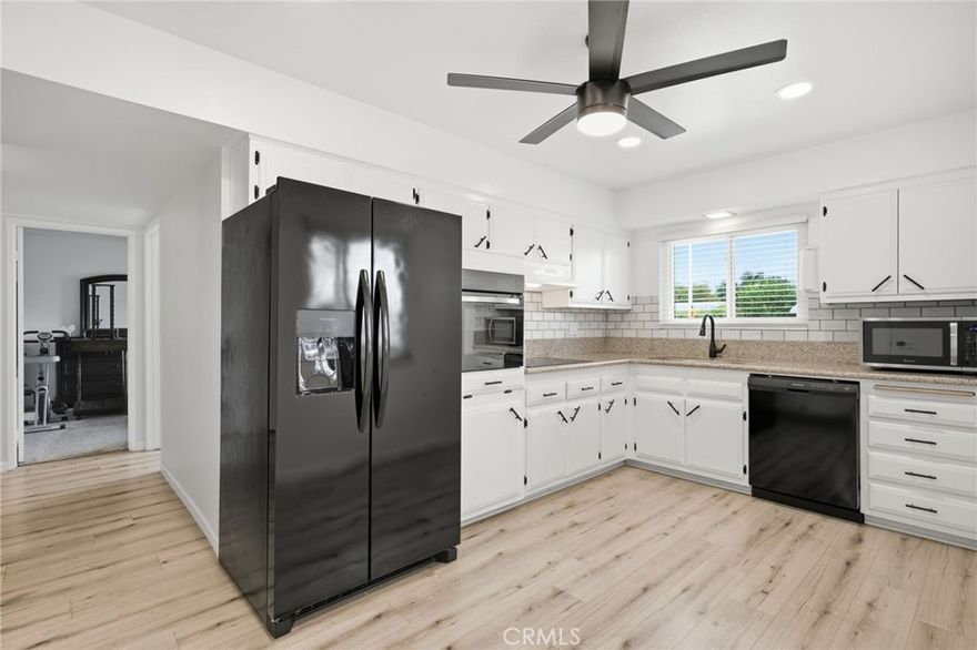 Wonderful 55+ upgraded property with an HOA that pays for your common ground maintenance, water, trash, sewer and more!  This property is upgraded and has LVP flooring, new kitchen countertops and fresh paint, newer dual pane windows and sliding door and newer water heater.  The primary bedroom is spacious with upgraded newer carpet and a primary bathroom with new vanity and upgraded shower.  The guest bedroom is currently used for an office but it's very spacious for a secondary bedroom with closet and there's a bathroom with upgraded, new vanity and full shower/bath combo as well.  The kitchen has a newer oven/stove/dishwasher and beautiful backsplash.  The whole house has newer windows and sliding door out to the patio which has bougainvillea bushes and artificial turf and epoxied concrete for a clean/relaxing/[private backyard area.  There's also a covered separate upgraded room for laundry with additional cabinets and counterspace for cabinets.  The garage has built-in shelving for the ultimate workshop complete with ventilation from a fan installed in the ceiling recently.  This is a very upgraded and efficient home and has many amenities paid for by the HOA!