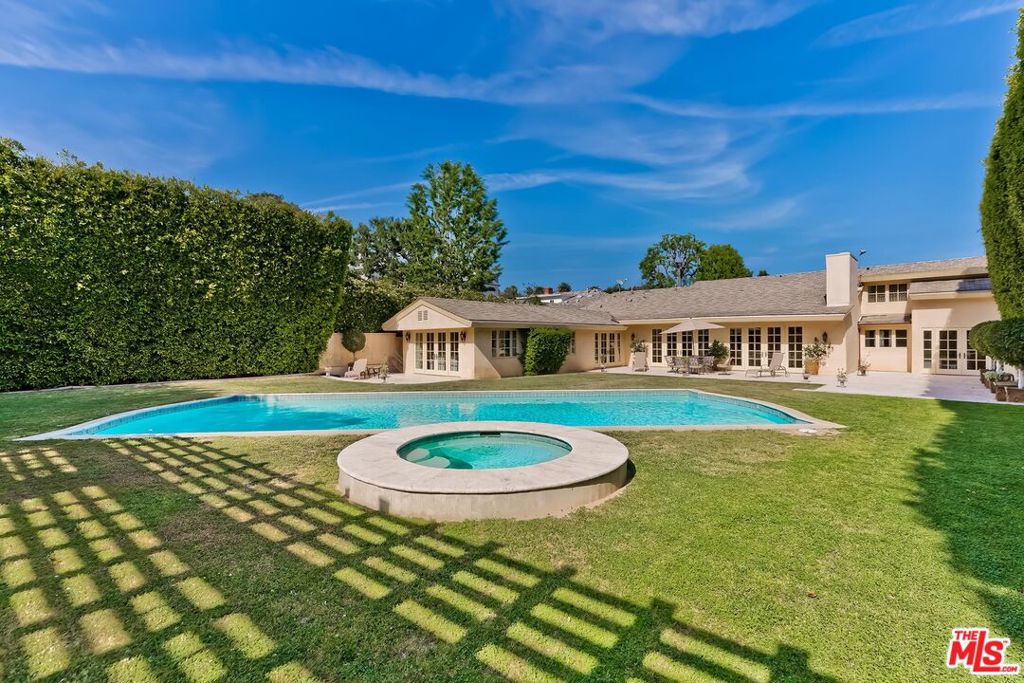 We are proud to present this voluminous and casually elegant 1.5sty European-inspired Villa which had a custom renovation executed in the mid 2000's. Set on a tremendously deep 19,970 sq ft lush lot surrounded by mature hedging, the home features spacious sunlit rooms with mouldings, French doors, and stunning walnut floors. Open flow for intense entertaining capabilities and a flexible floor plan for one or many. Huge great room, kitchen/breakfast area, and huge main floor owner's suite (highlighted by a luxe bath and walk-in) all open to glorious grounds with dense privacy hedging, endless lawns, patios, pool, spa, pergola. Fabulous large cook's kitchen with beautiful cabinetry and top appliances. Two other bedroom suites are on the main floor with two more fantastic suites upstairs. Lower level storage room is an added bonus. Complimented by discreet curb appeal behind high hedges and approached by an oversized motorcourt, this gem is sited on one of the quietest Jacaranda tree-lined roads in the Flats of Beverly Hills and moments from all of the finest amenities in the Westside, Sunset Strip, and West Hollywood.