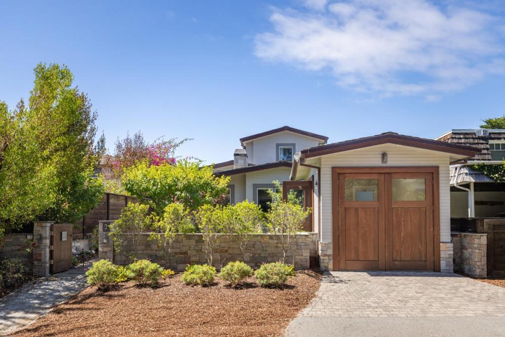Located in Carmel-by-the-Sea's coveted Golden Rectangle, this refined coastal retreat blends timeless design with modern luxury. Remodeled in 2014, every element of the home reflects thoughtful craftsmanship and elevated beachside living. Expansive sliding doors dissolve the boundary between indoors and out, leading to multiple outdoor living spaces designed for both relaxation and entertaining. The main level hosts two bedrooms, including the serene primary suite, both with a Scandinavian-inspired fireplace. The primarys spa-like bathroom features a freestanding soaking tub with tranquil garden views and ocean peeks. Upstairs, a sunlit guest suite is surrounded by windows that capture sweeping vistas and opens directly onto the rooftop deck. Ideal as a beach getaway or full-time retreat, this home captures the essence of Carmel living.