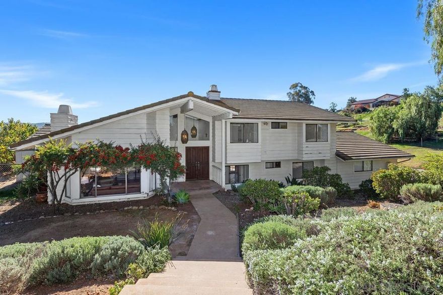 If you are looking for a spacious home along with unobstructed views of the nearby mountains, serenity and privacy on 2.81 acres, this may be the one for you!  This hacienda style home has beautiful Spanish tile throughout, wood beam vaulted ceilings in the formal living room, views out of every window and French door. In addition to the circular driveway, there is a 2nd driveway that takes you out to the citrus grove or possible pasture if you have horses. There's plenty of room all of your passions.