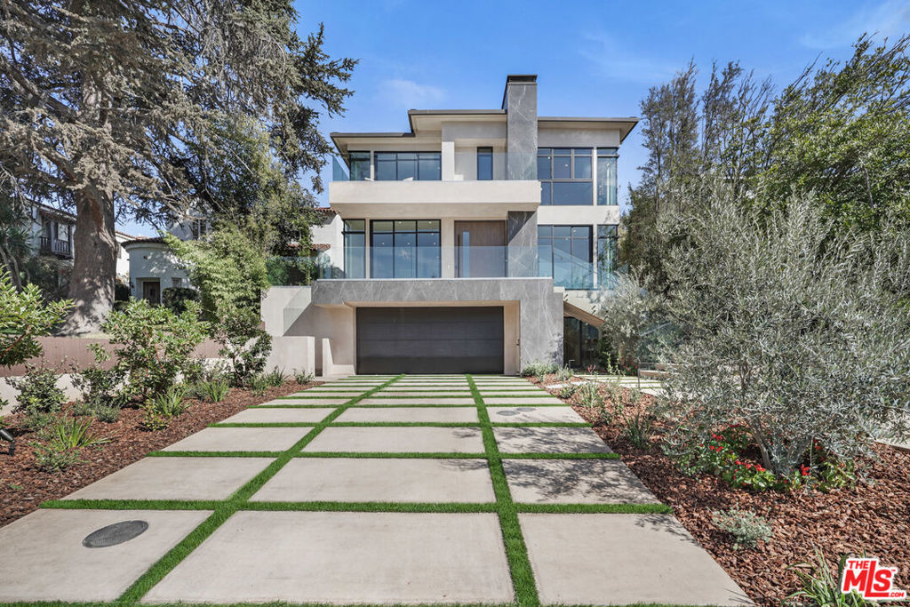 318 Medio Drive is an architecturally striking residence situated in the heart of Brentwood. Defined by warm, natural tones and a modern aesthetic, the home combines clean lines, a thoughtful floor plan, and a refined selection of materials to create an elevated living experience. The main level features a sleek, open layout ideal for both daily living and entertaining. The designer kitchen is equipped with state-of-the-art Miele appliances and connects seamlessly to the living and dining areas. Floor-to-ceiling glass doors extend the interiors to the landscaped backyard, where a pool, spa, and built-in BBQ provide a private setting for outdoor enjoyment. A rare highlight of the property is the 2,000-square-foot entertainer's basement, complete with a spa and flexible space for leisure, wellness, or relaxation. The upper level includes three generously sized bedrooms, complemented by a primary suite with fireplace, private terrace, dual spa-like bathrooms, and oversized walk-in closets. High ceilings, natural light, and sophisticated finishes are carried throughout the residence. With its architectural integrity, luxury amenities, and premier Brentwood location just moments from the shops and restaurants of San Vicente Boulevard, 318 Medio Drive presents an exceptional opportunity to reside a distinguished property in one of Los Angeles' most sought-after neighborhoods.
