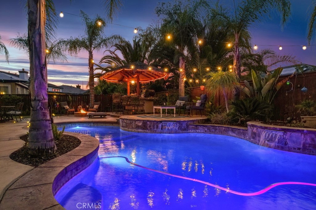 Luxurious 5-Bedroom Entertainer's Paradise with Pool and Spa. Welcome to your dream home! This stunning 5-bedroom, 3,752 sq ft residence is the ultimate entertainer’s retreat, featuring a solar-heated saltwater pool, above-ground spa, Palapa bar and BBQ. Enjoy the California lifestyle in your backyard oasis, complete with a gas fire pit and putting green. Inside, you’ll find high ceilings, elegant crown molding, hardwood floors, and plantation shutters throughout. The spacious great room boasts a cozy fireplace and a built-in entertainment center, creating a warm and inviting space for relaxing or hosting guests. The chef’s kitchen is equipped with granite countertops, a custom tile backsplash, double ovens, stainless steel appliances, and tile flooring. A downstairs bedroom with a closet and dedicated exercise area offers flexibility for a home office, gym, or guest retreat, perfect for today’s versatile lifestyle. Upstairs, the double-door entry leads into a luxurious primary suite featuring dual walk-in closets, dual vanities, a relaxing soaker tub, and a spacious layout perfect for unwinding. The open loft serves as a library and sitting area, overlooking the living space below, while a spacious guest suite offers privacy with its own full bath. Ceiling fans throughout the home ensure comfort in every room. This home is truly a one-of-a-kind opportunity—luxury, comfort, and entertaining all in one perfect package. **Bundled service pricing available for buyers**