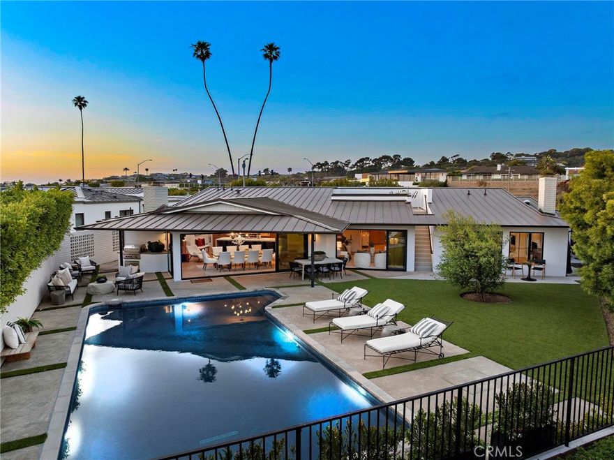 Experience the ease of Southern California living in this stunning single-level residence, masterfully remodeled in 2021. This home underwent a comprehensive transformation — completely gutted and reimagined with no surface left untouched. Every inch of this property reflects a commitment to quality, style, and modern comfort. Located in the highly desirable Cameo Shores neighborhood, 4709 Hampden Road sits on an over quarter-acre lot at the end of a rare cul-de-sac, adjacent to lush green space offering exceptional privacy and tranquility. Designed with a refined contemporary aesthetic, the home blends coastal sophistication with midcentury modern style. Vaulted ceilings, rich hardwood flooring, and an open-concept layout create a bright, airy atmosphere perfect for both everyday living and elegant entertaining. At the heart of the home is a chef’s dream kitchen, outfitted with premium Wolf and SubZero appliances, an oversized waterfall-edge island, and sleek cabinetry. The kitchen seamlessly integrates with the expansive living and dining areas, which are framed by custom La Cantina sliding doors that open completely to the beautifully redesigned backyard. Here, an upgraded pool, outdoor kitchen, and multiple lounge and play areas with fresh landscaping offer the ultimate outdoor lifestyle. Four ensuite bedrooms, including a luxurious primary suite, provide private sanctuaries for family and guests. The primary suite boasts a spa-inspired bathroom with an oversized shower, freestanding tub, and generous walk-in closet. Additional standout features include a rare rooftop deck with ocean views and new smart home wiring with a dedicated media closet. Behind the scenes, every major system has been upgraded — from plumbing and sewage to electrical, HVAC, and home automation infrastructure. With exclusive private access to Cameo Shores beach and green space, and just minutes from Corona del Mar, Fashion Island, Crystal Cove, and Pelican Hill Resort, this turnkey residence is a rare opportunity to own one of the most extensively renovated homes you will ever encounter in this price point within this exclusive community.