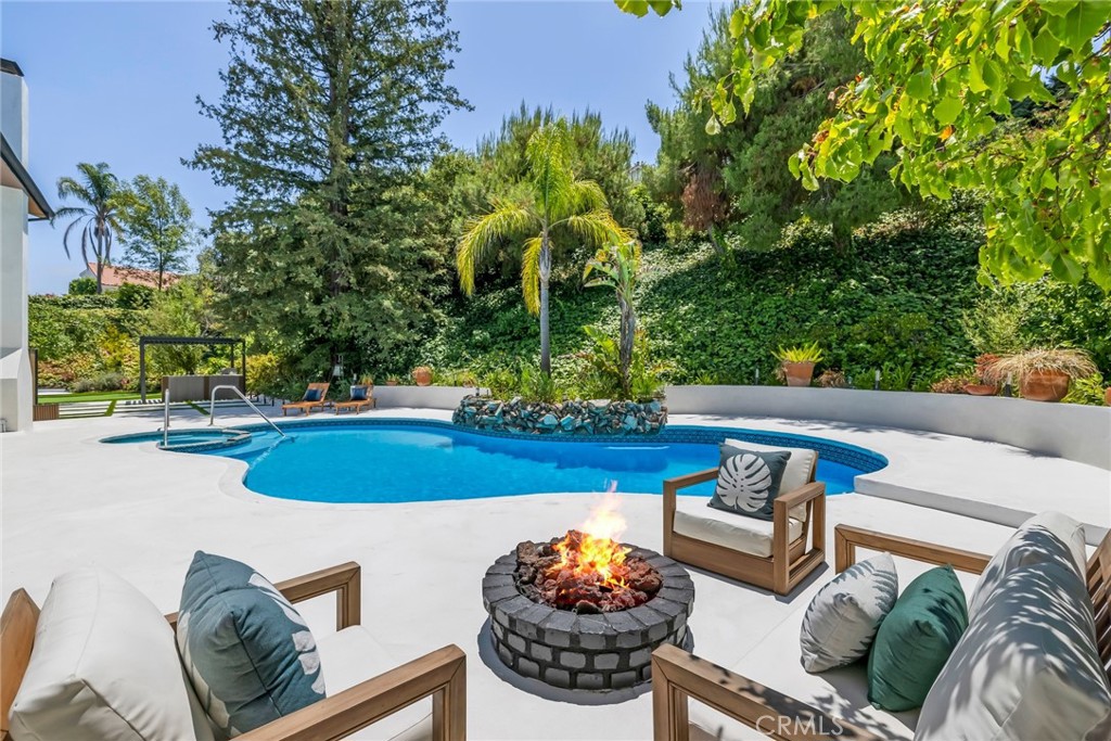 Welcome to 20101 Greenbriar Drive, an architectural masterpiece nestled in the serene hills of Tarzana. This newly remodeled 5-bedroom, 4-bathroom estate spans nearly 3,500 square feet of open-concept luxury, situated on a large 21,000+ sq ft lot with SWEEPING VALLEY VIEWS and incredible outdoor living. Step through the dramatic entrance into soaring ceilings, oversized windows, and designer tile floors that reflect natural light throughout the open-concept floorplan. A custom floating staircase, sleek lighting fixtures, and expansive living areas give the home an art-gallery feel—equal parts inviting and impressive. Enjoy sweeping valley and mountain views from the living room’s oversized picture windows. The brand-new chef’s kitchen flows effortlessly into the indoor-outdoor lounge area, anchored by a modern fireplace and floor-to-ceiling sliding doors that open to a private backyard oasis. Outside, indulge in your own resort-style retreat with a sparkling pool, lush landscaping, and a large patio perfect for entertaining or relaxing in the sun. Other highlights include a luxurious primary suite, spa-inspired bathrooms, a 3-car garage, and high-end finishes throughout. Located moments from Ventura Blvd’s best dining and shops, yet tucked away in a quiet cul-de-sac, this property offers the perfect blend of privacy, elegance, and everyday convenience.