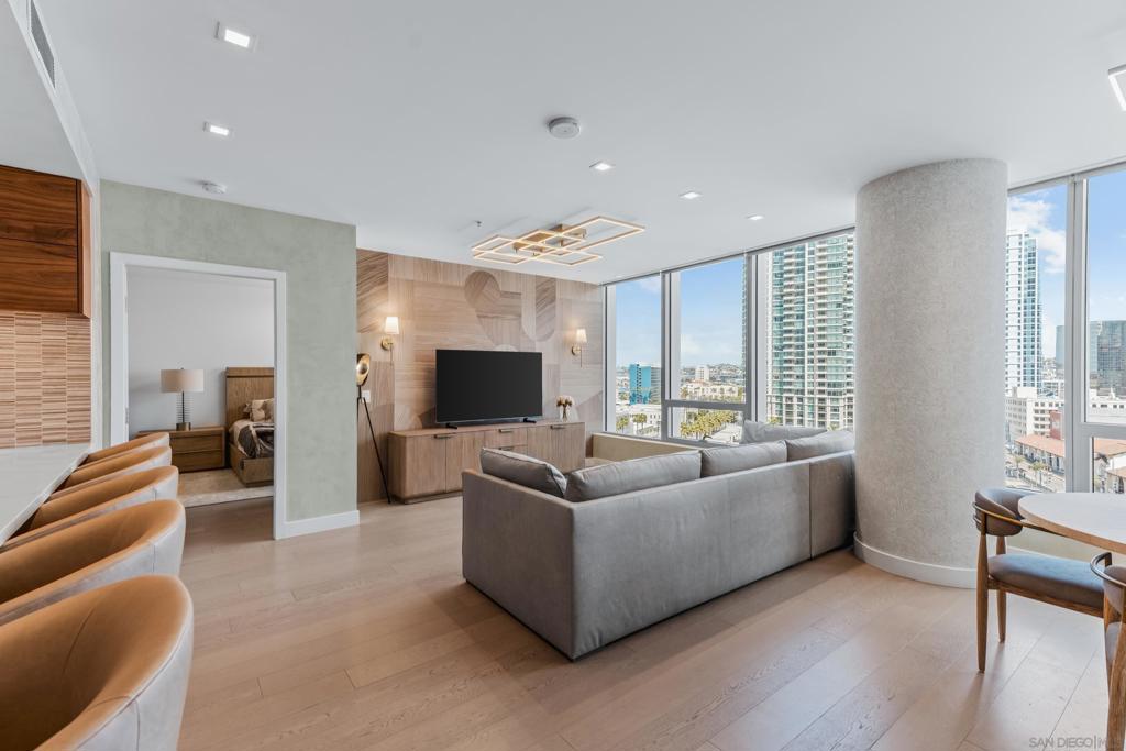 Experience the ultimate in luxury high-rise living at Pacific Gate, San Diego’s iconic waterfront address. Residence 1106 is a stunning 2-bedroom, 2-bath home spanning 1,390 sq. ft., offering an elegant blend of modern design and urban comfort. Expansive glass walls fill the home with natural light, showcasing dynamic city views framed by the downtown skyline. The open-concept living space features sophisticated upgrades like new wall coverings, fresh paint, and stylish lighting enhancements for added comfort and style. A split-bedroom layout ensures privacy and flexibility, while the private covered terrace extends your living area outdoors. The generous primary suite offers an elegant walk-in closet by California Closet Systems and a spa-inspired bath with heated floors, a walk-in shower, a soaking tub, and an anti-fog electric mirror with an integrated 10” TV screen. Automated blinds and a Smart Home system with climate control add convenience throughout the residence. The second bedroom offers flexibility as a home office or guest retreat. Residents enjoy unparalleled resort-style amenities including a private yacht share, luxury car fleet, chef concierge, guest suite, state-of-the-art fitness center with sauna and steam room, residents’ lounge, and an on-site restaurant led by a celebrity chef. Ideally located just steps from the bay, this residence is moments from Seaport Village, the Rady Shell, the new RaDD development, and San Diego’s finest dining, shopping, and entertainment. The first all-glass Super Prime residential tower in San Diego offers an unprecedented waterfront lifestyle with sky-high amenities and picture-postcard views. Directly overlooking the waterfront, the 41-story tower contains an exclusive offering of homes designed by Hirsch Bedner Associates. Renowned New York-based architectural firm Kohn Pedersen Fox (KPF) created a landmark that reimaged the San Diego skyline. The custom-engineered glass walls dynamically reflect the hues of the sky and the Pacific Ocean. Pacific Gate has evolved the San Diego skyline and represents the future of the city. The building is comprised of two-nested curved glass towers that rise as a single column from a three-story ground floor retail podium on the north and west sides of the tower. Because of the building’s curves and exterior glass, Pacific Gate offers a striking viewing experience from every vantage point. Residents arrive home to a beautifully landscaped motor court with a private luxury car fleet, which leads to a double-height lobby with a 24-hour concierge and porter services. Two levels of amenities boast a residents lounge ideal for events and everyday use, the fitness center contains an extensive range of state-of-the-art equipment. Adjacent to the fitness center is the steam and sauna retreats that open up to the fourth-floor pool terrace fitted with poolside cabanas and glass surround.